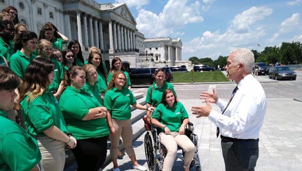 A group of students engaged in a conversation. They are in front of a building in Washington DC 