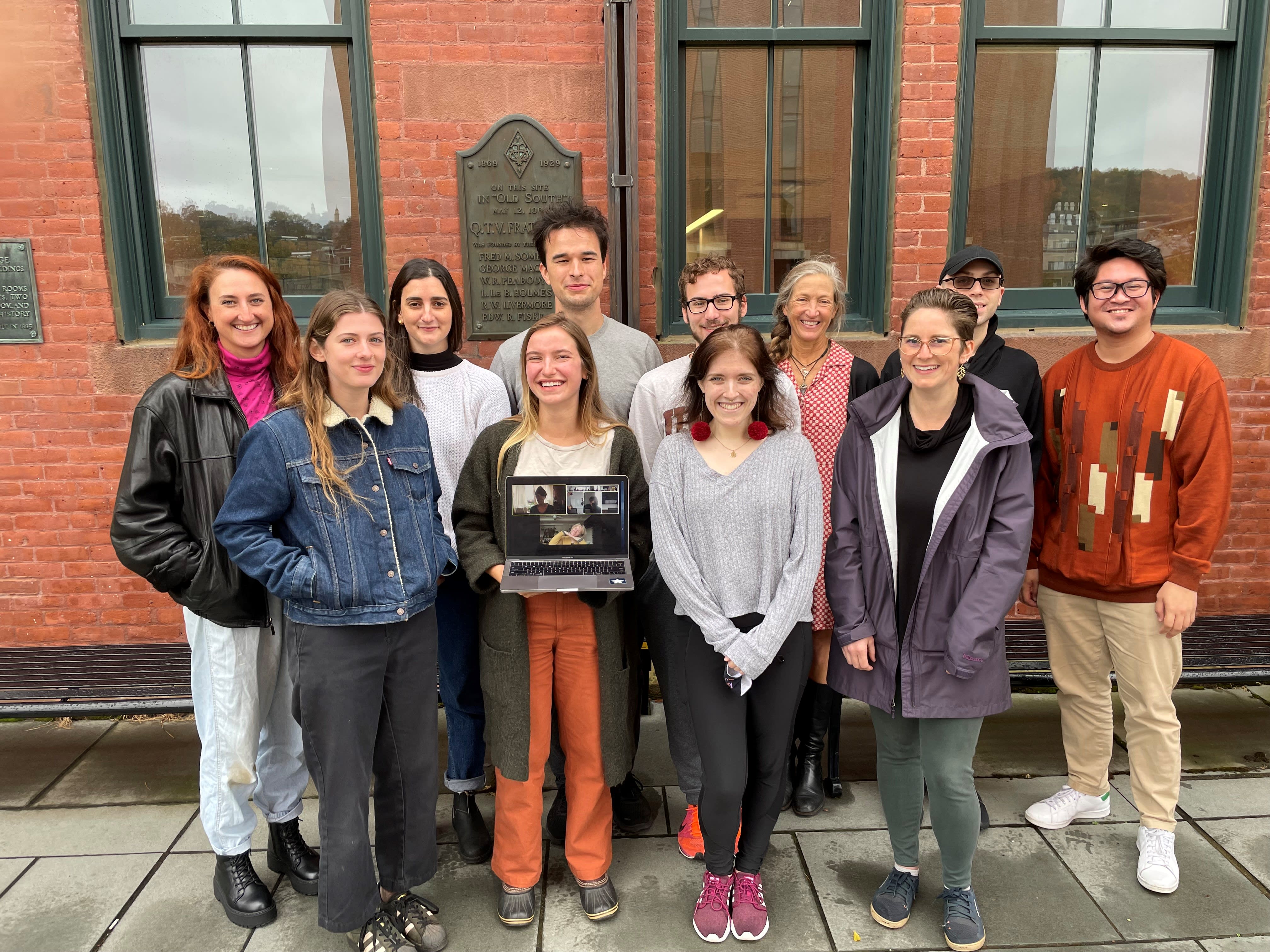 Ten students pose with Noy Holland for a group photo outside of South College
