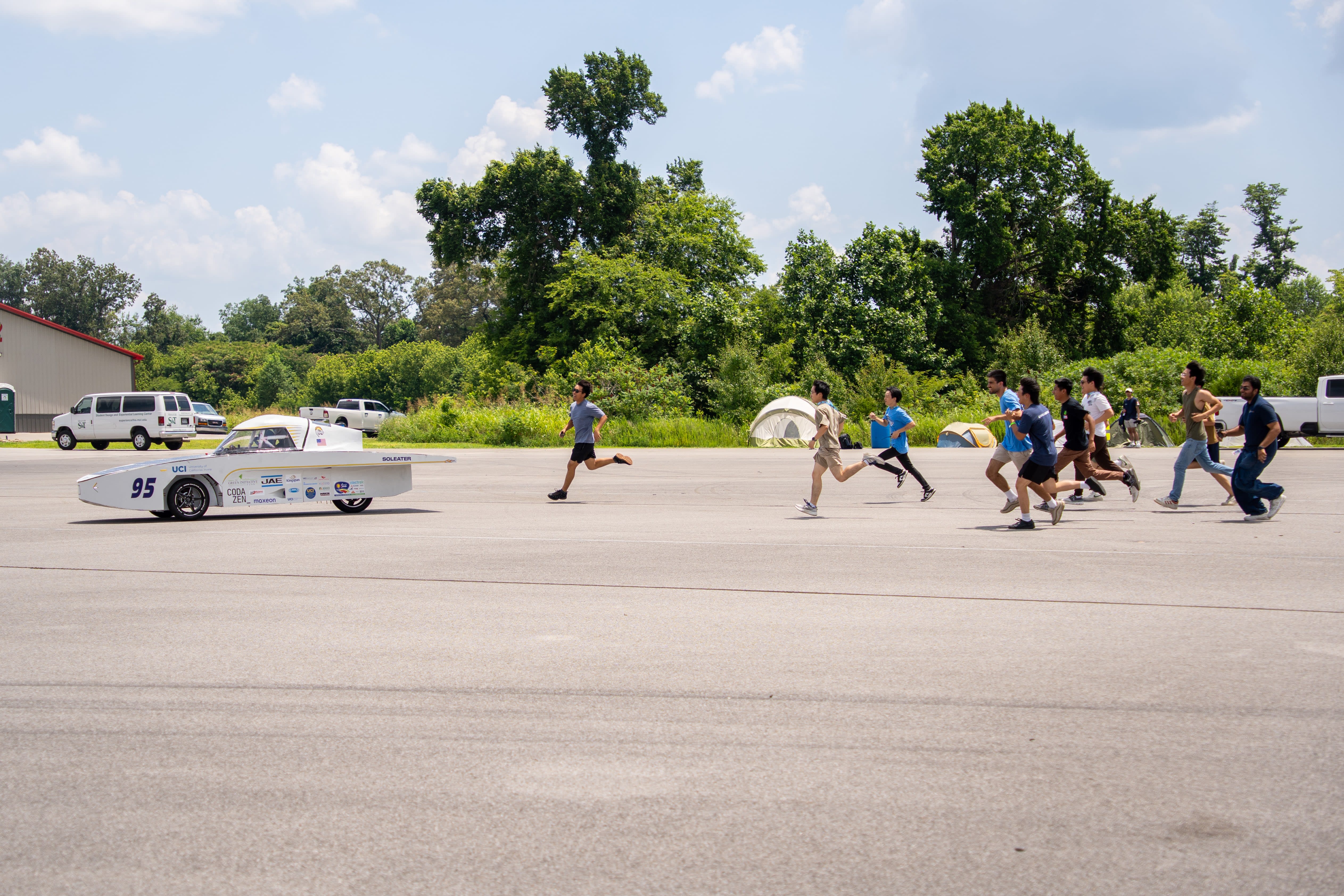 SolEater drives for the first time! The image shows SolEater in motion with much of the team running behind the car.
