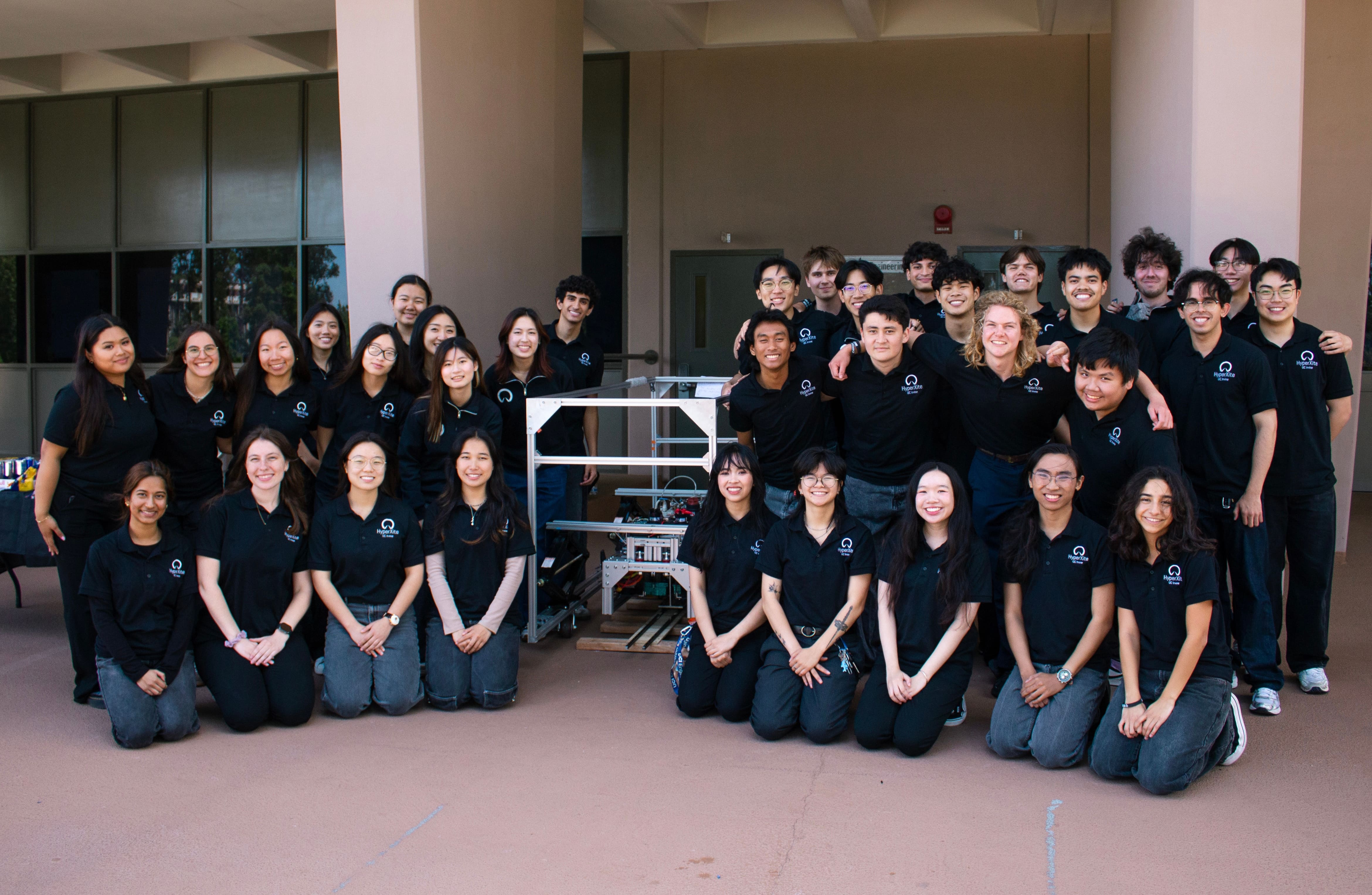 HyperXite team posing with pod while wearing matching T-shirts.