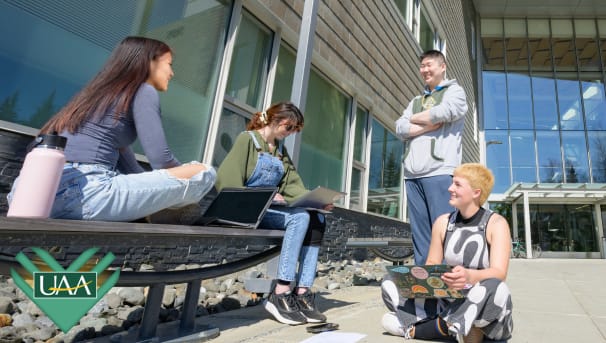 UAA students work together outside on an assignment.