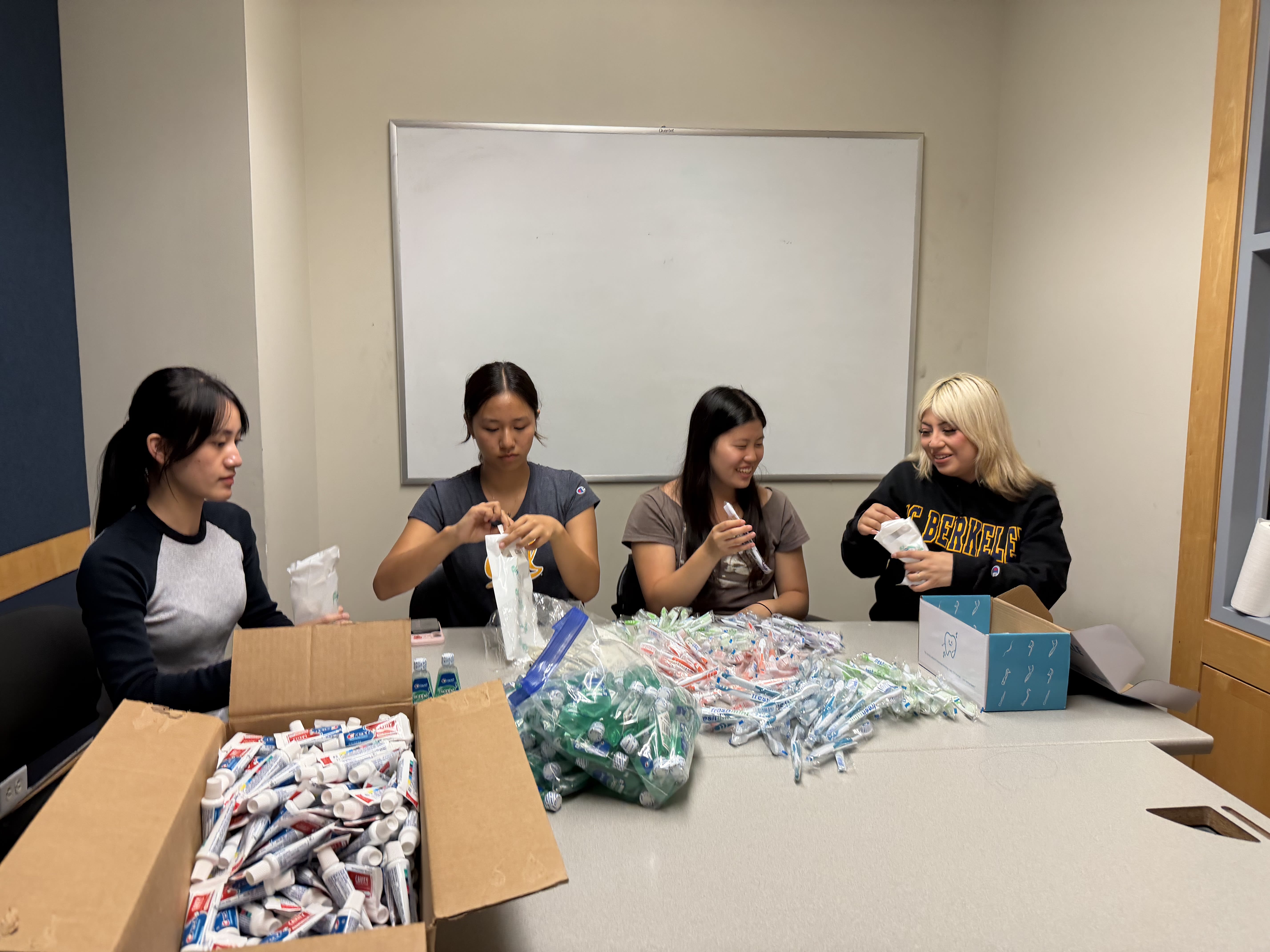 Four Project SMILE volunteers work together to make care packages.