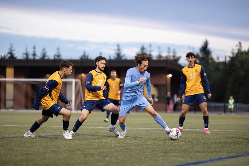 A group of men playing football

Description automatically generated