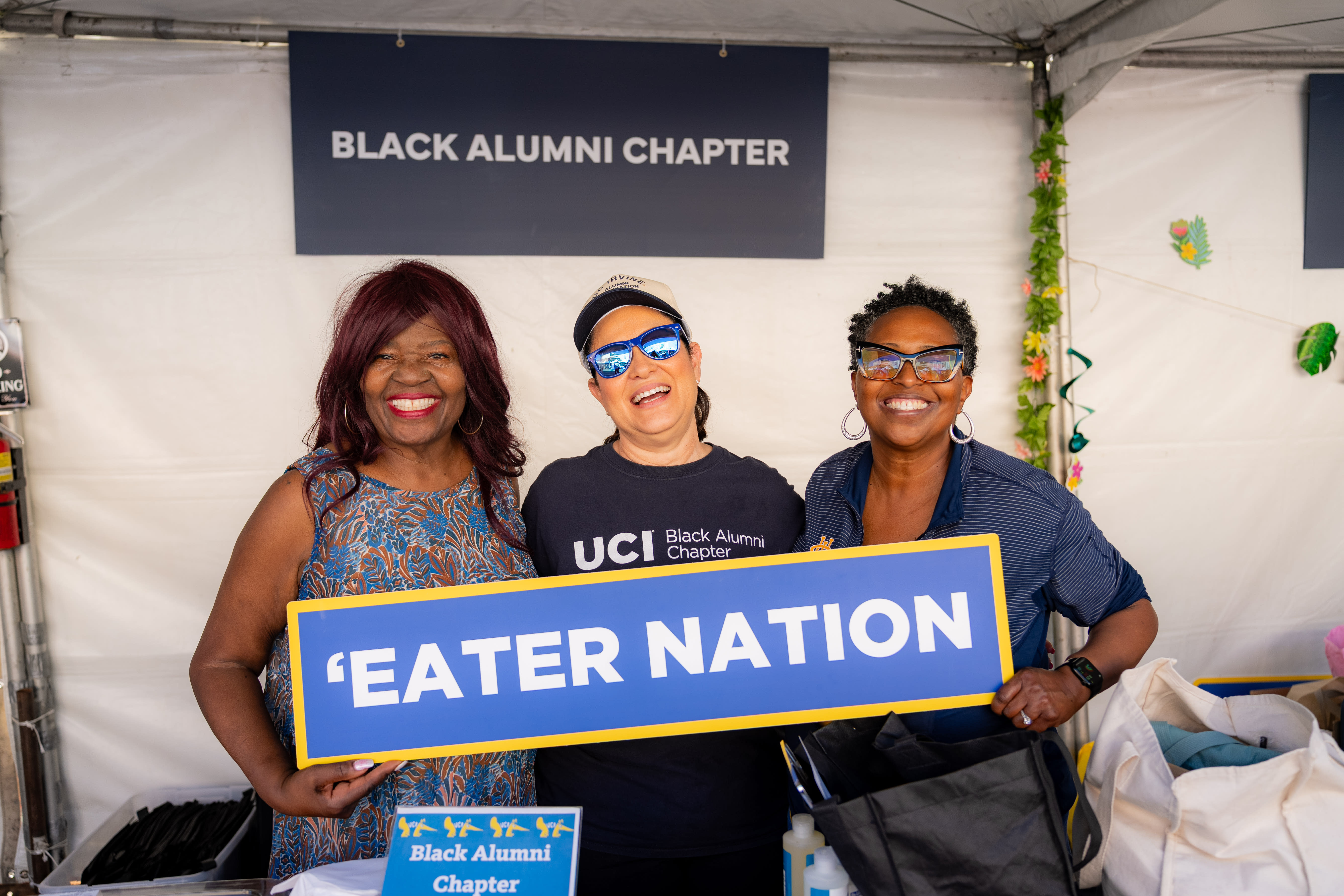 Members of the Black Alumni Chapter smiling as they hold up a sign that reads “Eater Nation.”
