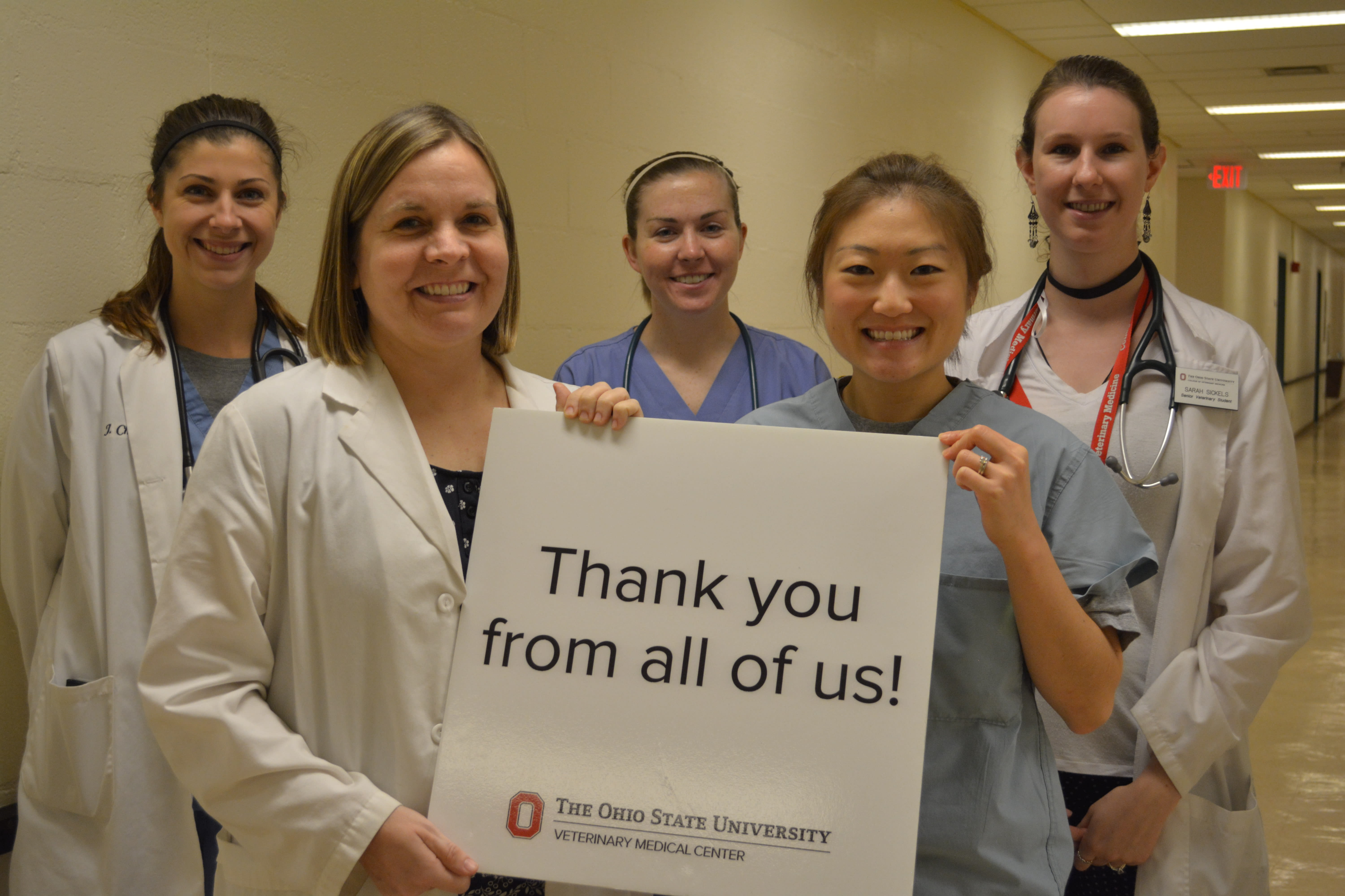 Five individuals from the Veterinary Medical Center holding a sign that says thank you from all of us