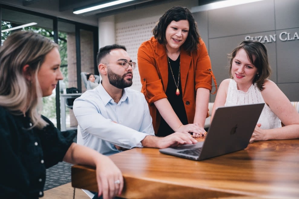 A group of people looking at a computer

Description automatically generated