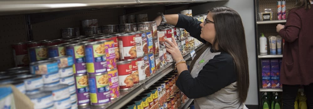 Image: FUEL student assistant stocking shelves