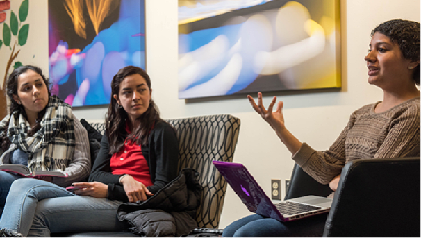 Two students intently watching another student speak 