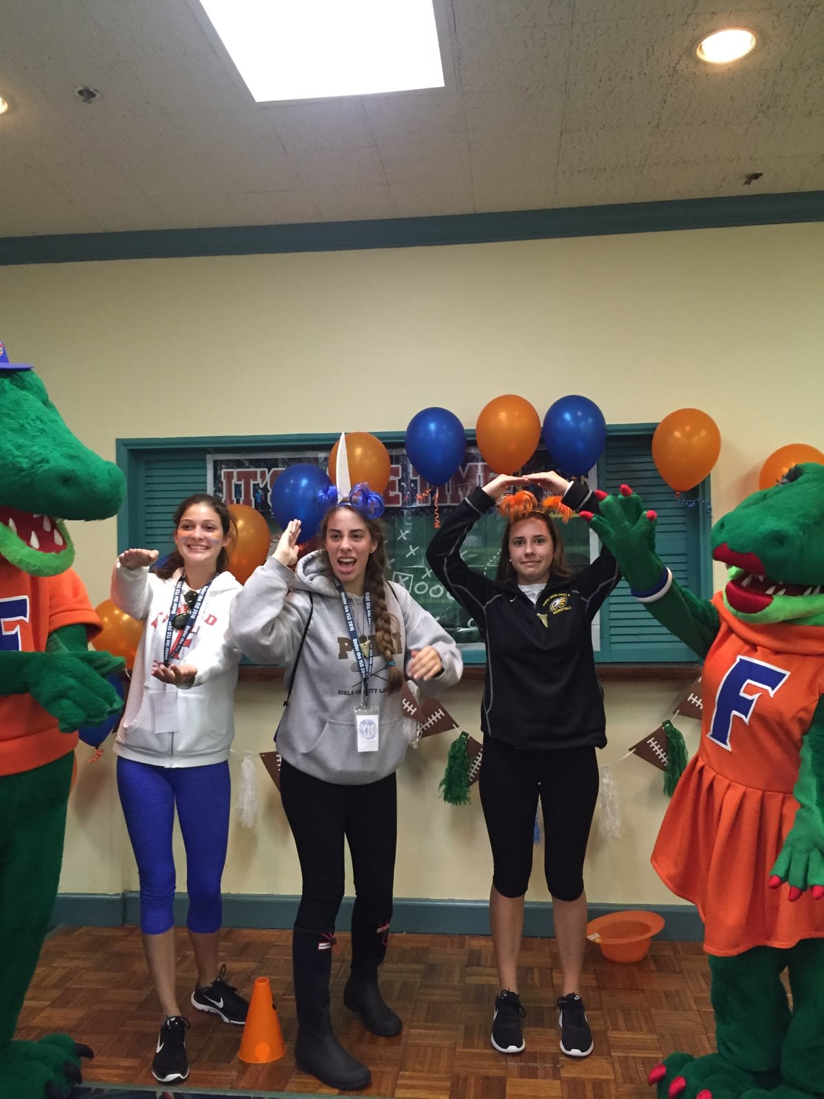 Three people posed with the Florida Gator mascots