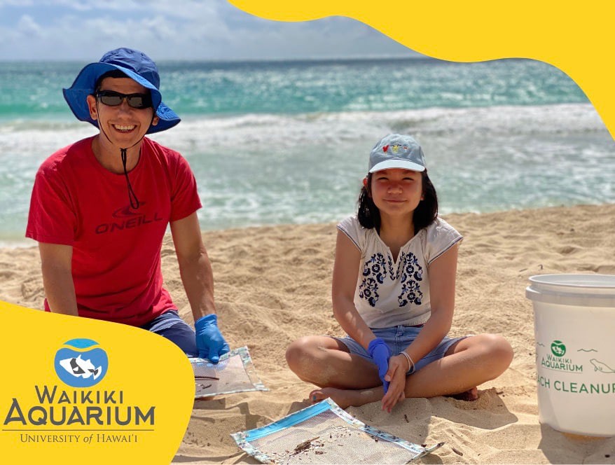 Father and daughter participating in a beach clean up.