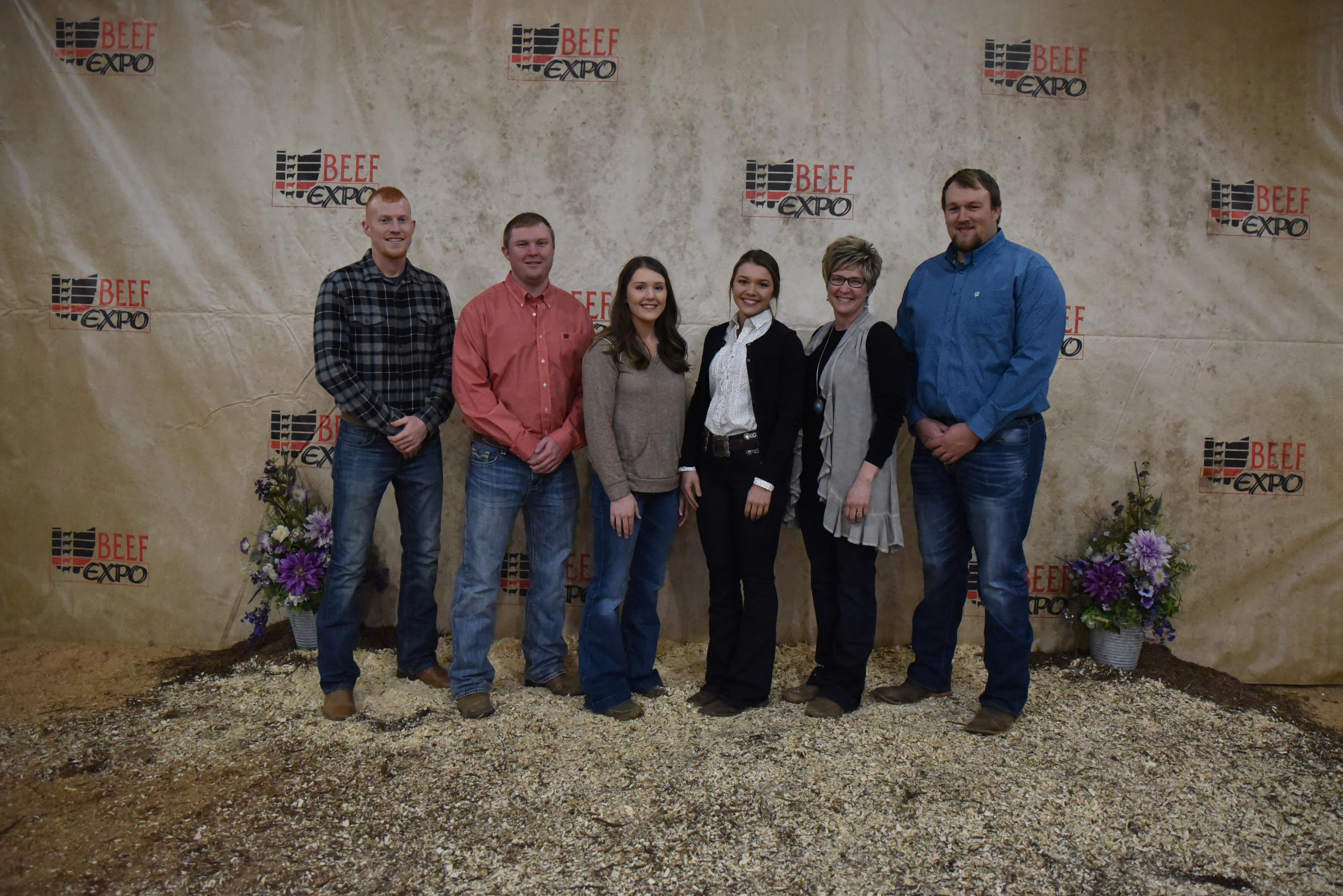Six members of the Davis Family stand together before the Beef Expo backdrop