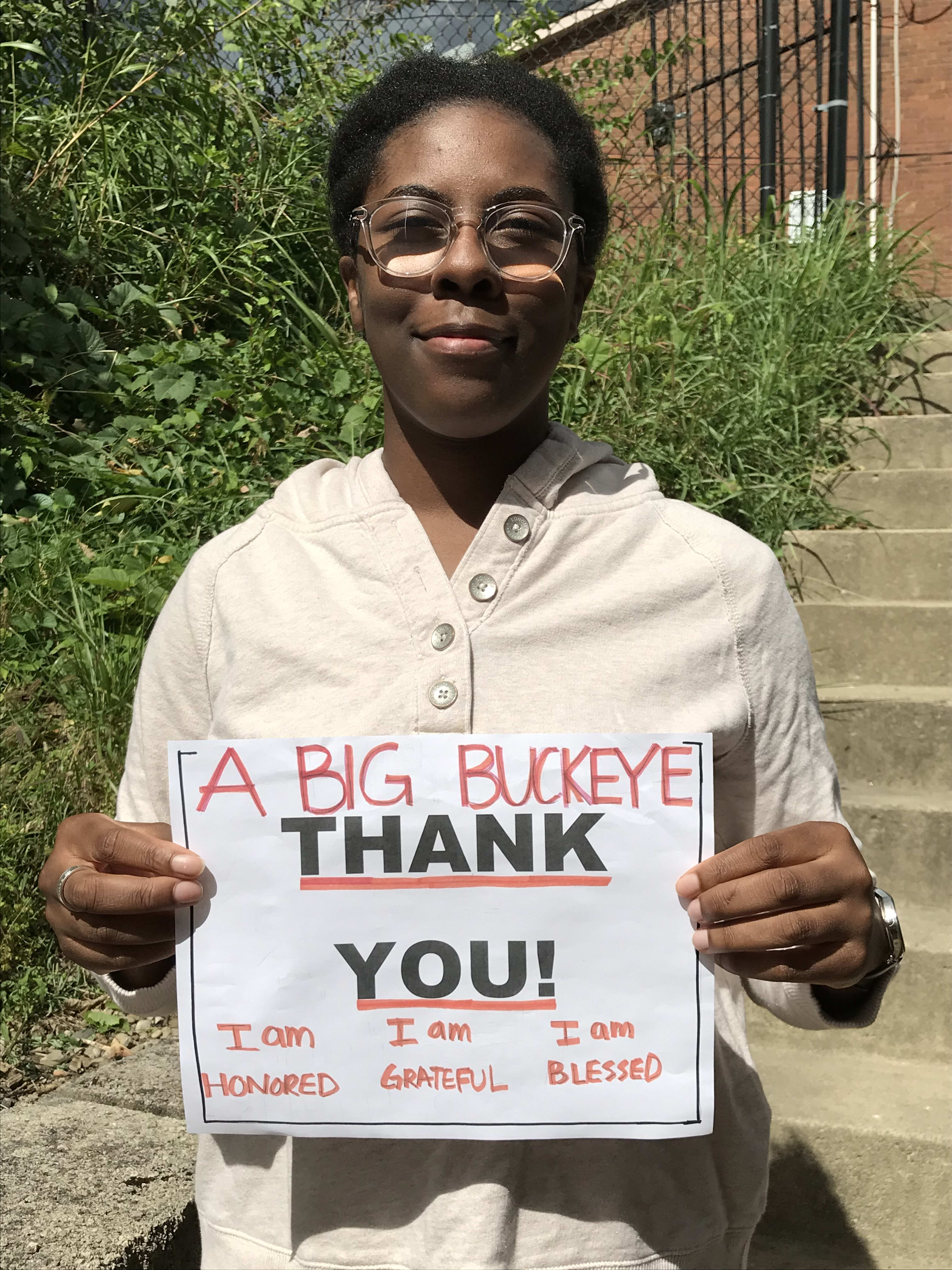 Max M. Fisher holding a sigh that reads 'A Big Buckeye Thank You!'