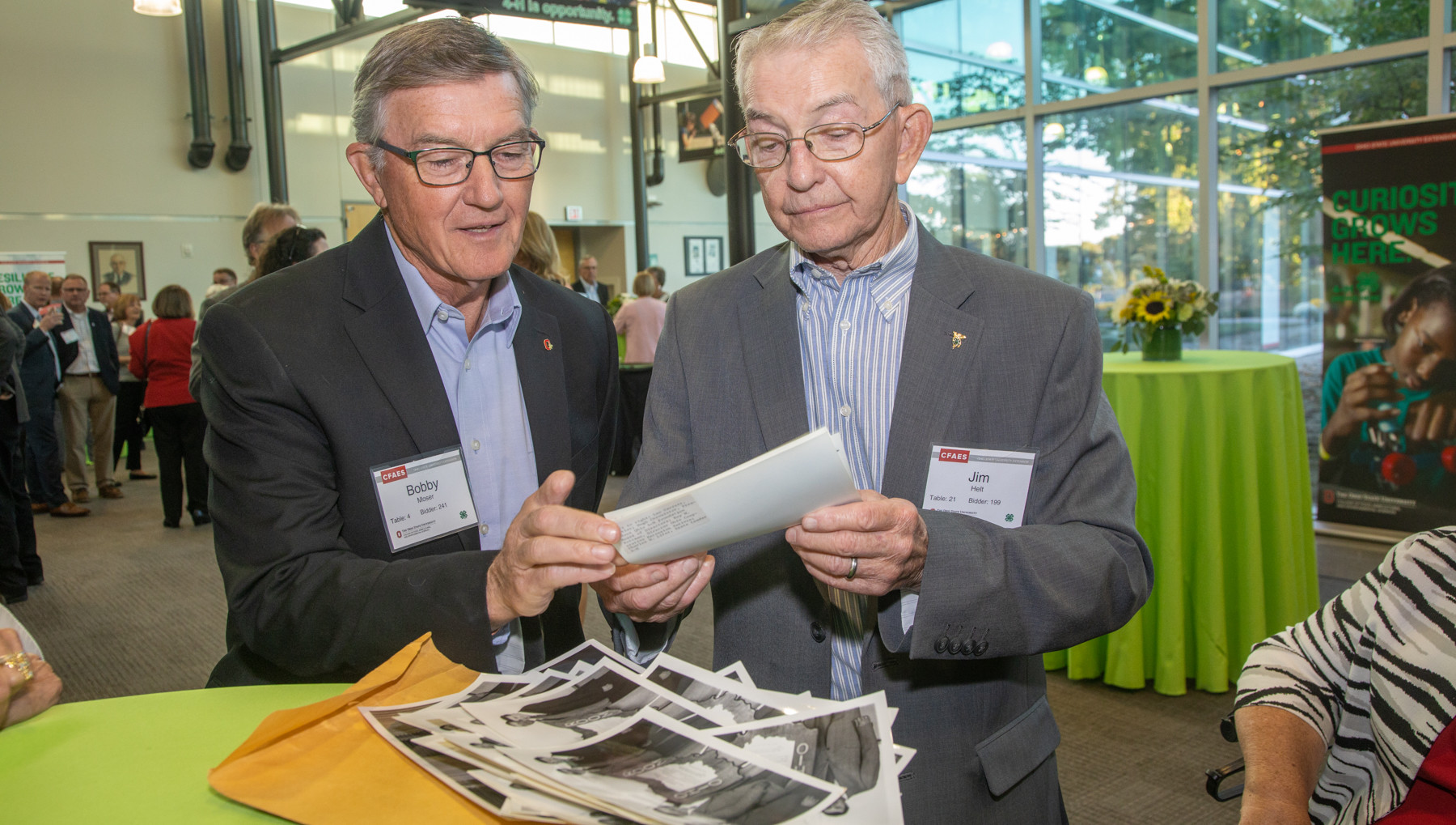 Two men looking at images at the 4-H Celebration of Youth event