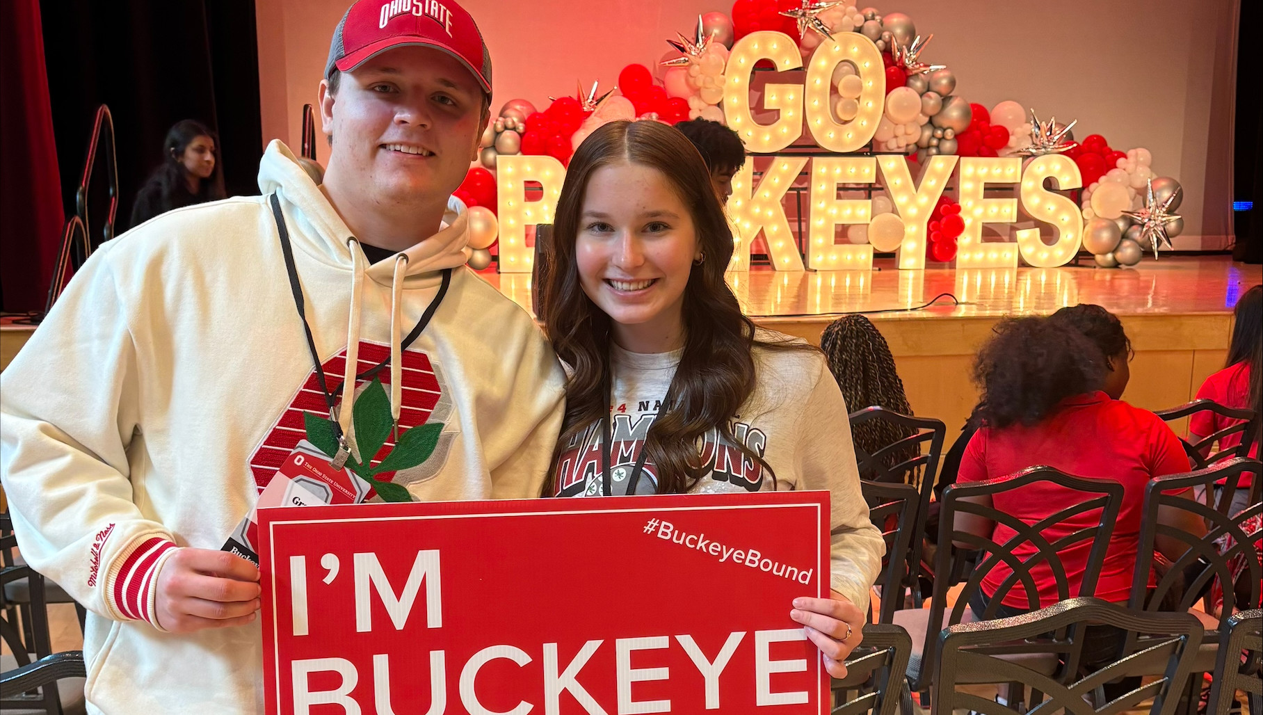 Two people holding a sign that says "I'm Buckeye Bound"