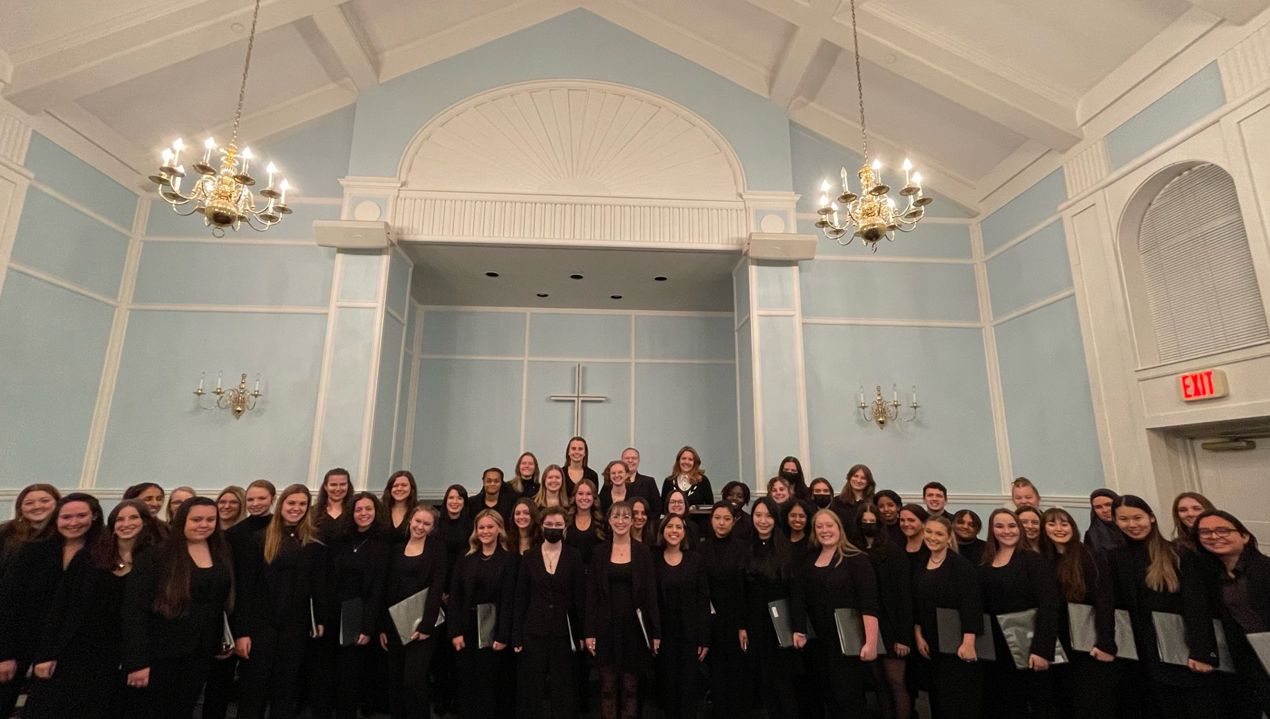 Women's Glee Club members posing for a group photo inside a church