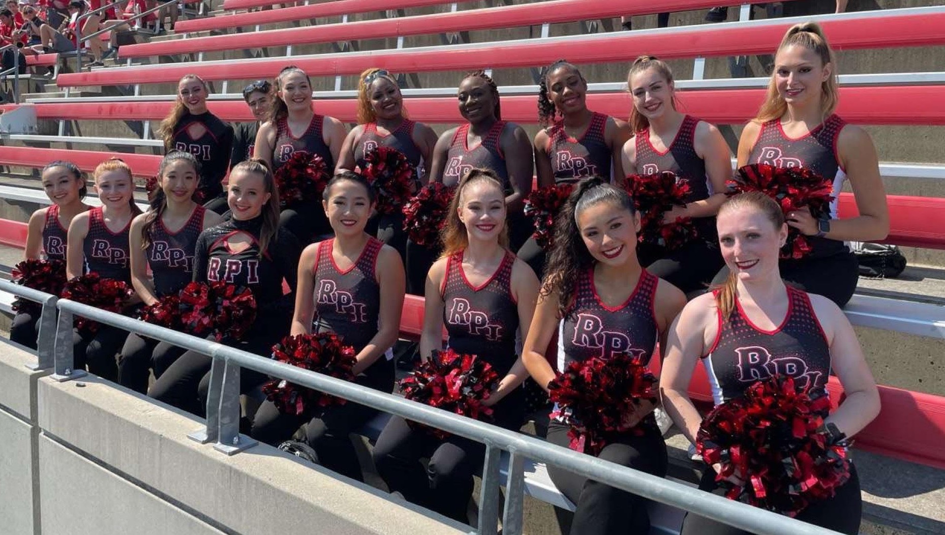 Members of the dance team sitting on the bleachers at ECAV