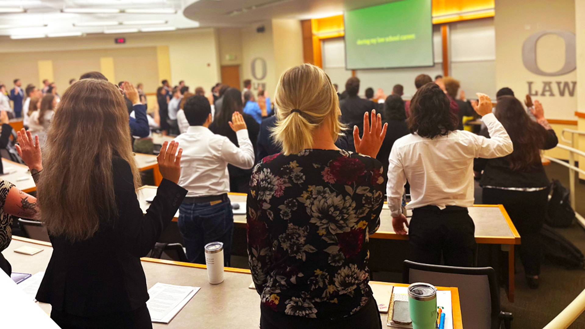UO Law students stand at desks with their right hands raised