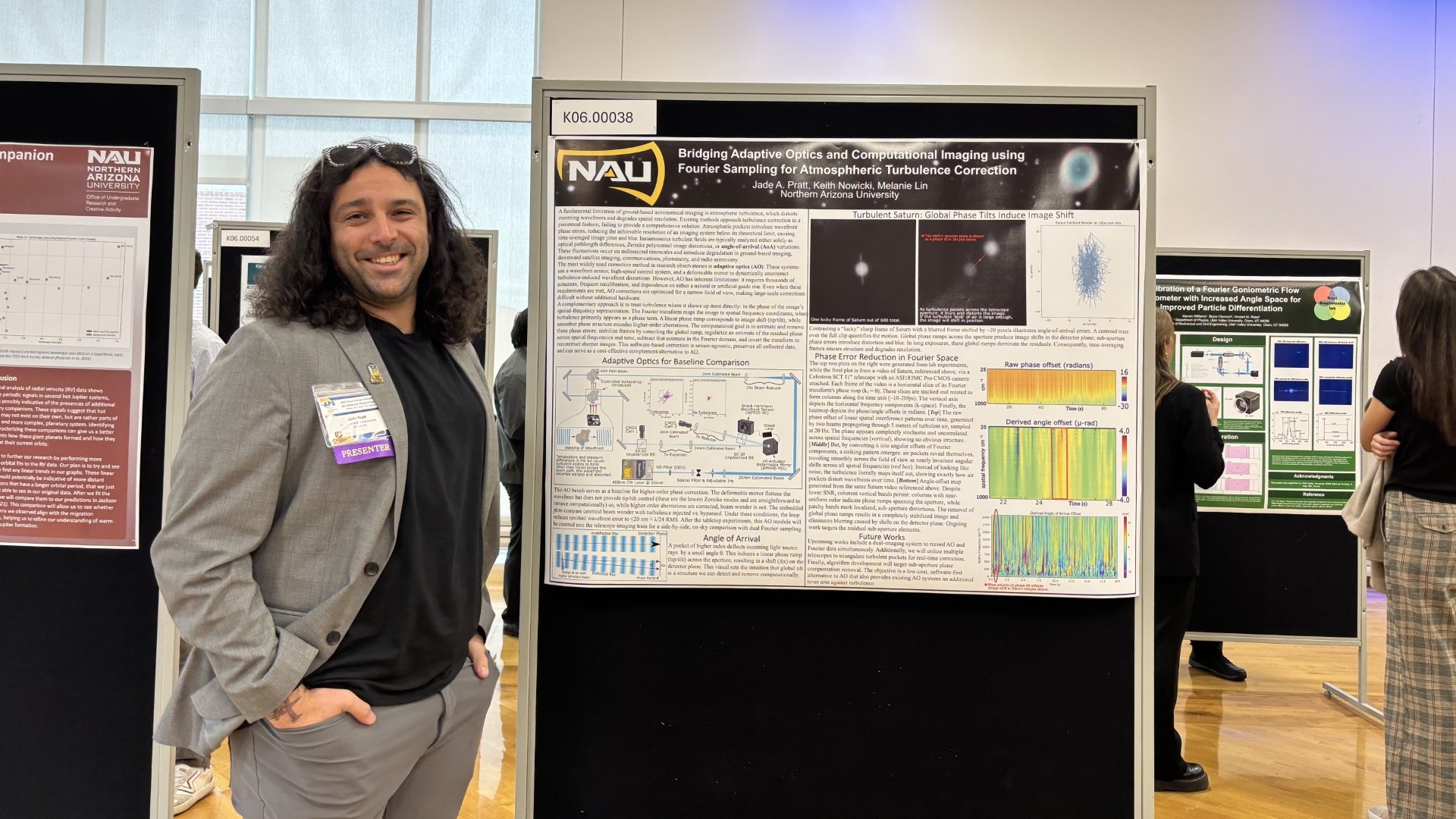 Physics student posing in front of research poster presentation.