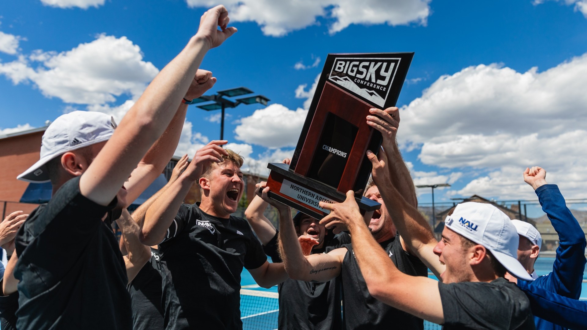 Men's Tennis team holding up the Big Sky Championship trophy.