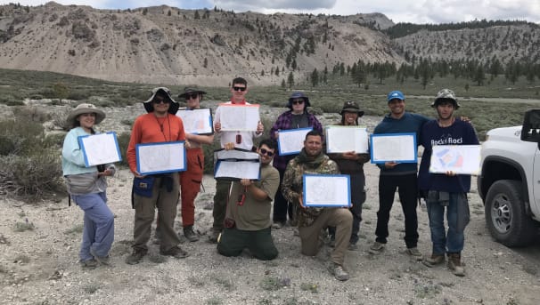 Students in the field holding maps