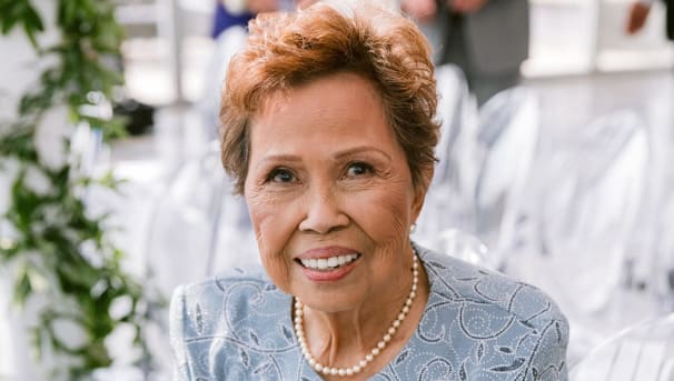 Individual smiling while sitting down at an event