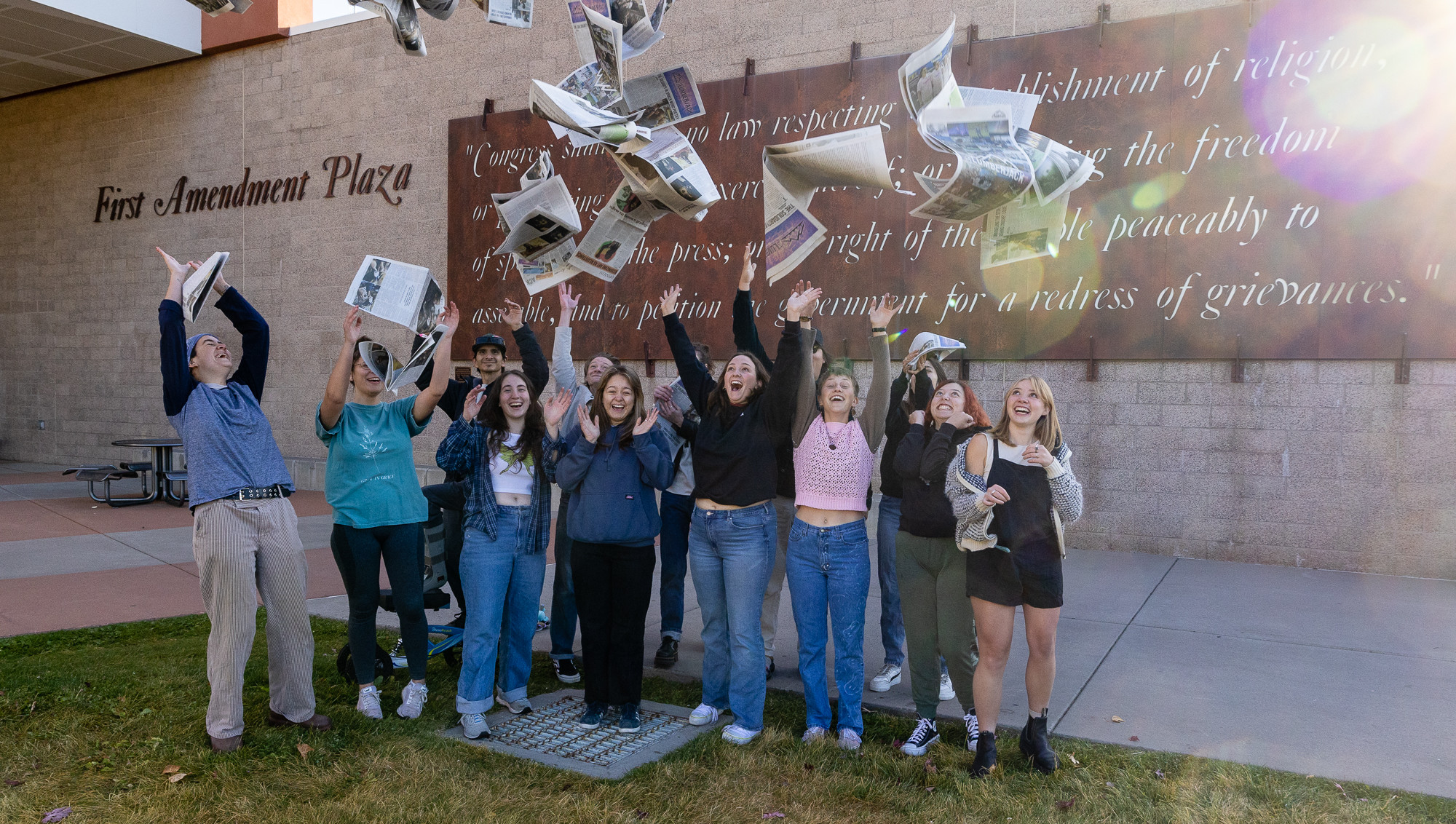 Staff of The Lumberjack hold the Arts Issue in front of the School of Communication at NAU.