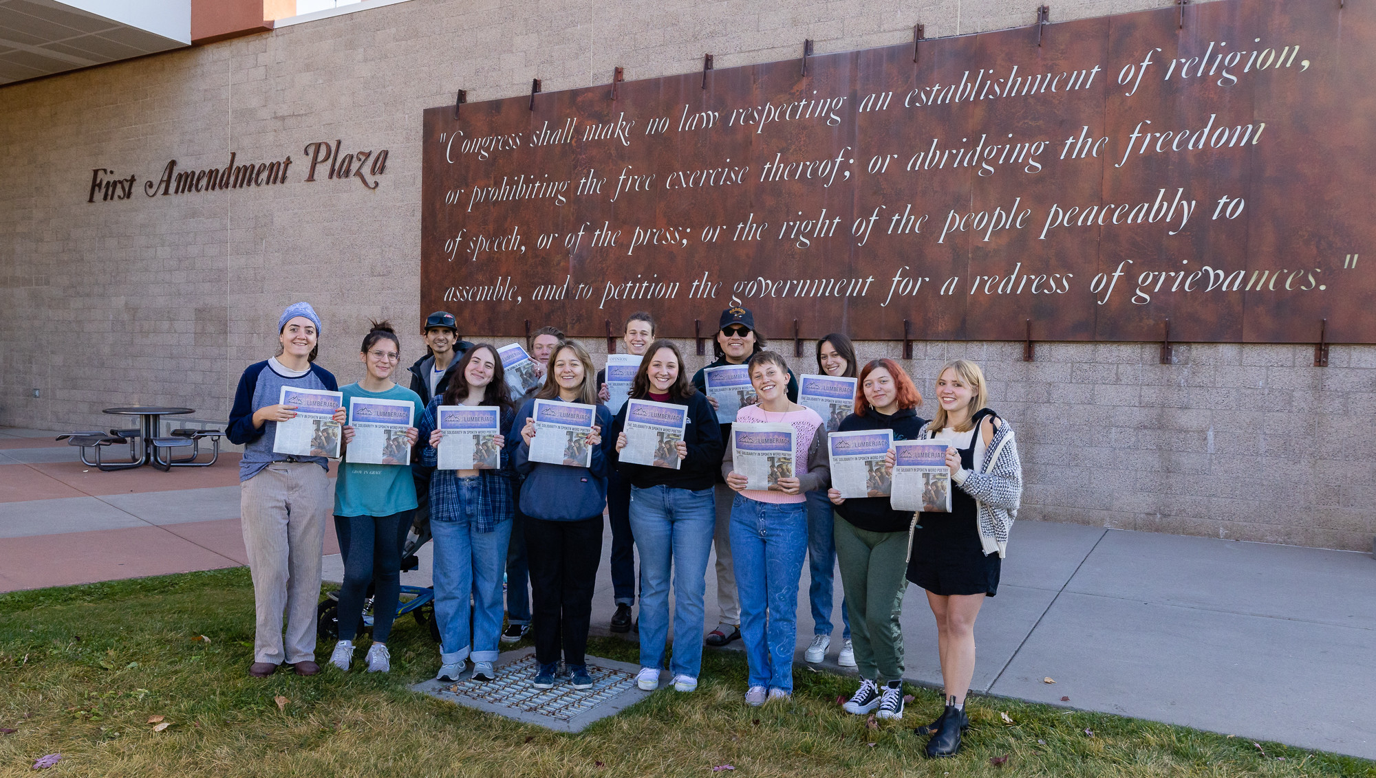 Staff of The Lumberjack hold the Arts Issue in front of the School of Communication at NAU.