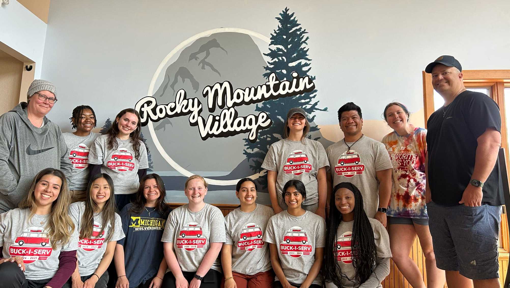 Buck-I-SERV participants posing for picture in front of Rocky Mountain Village sign