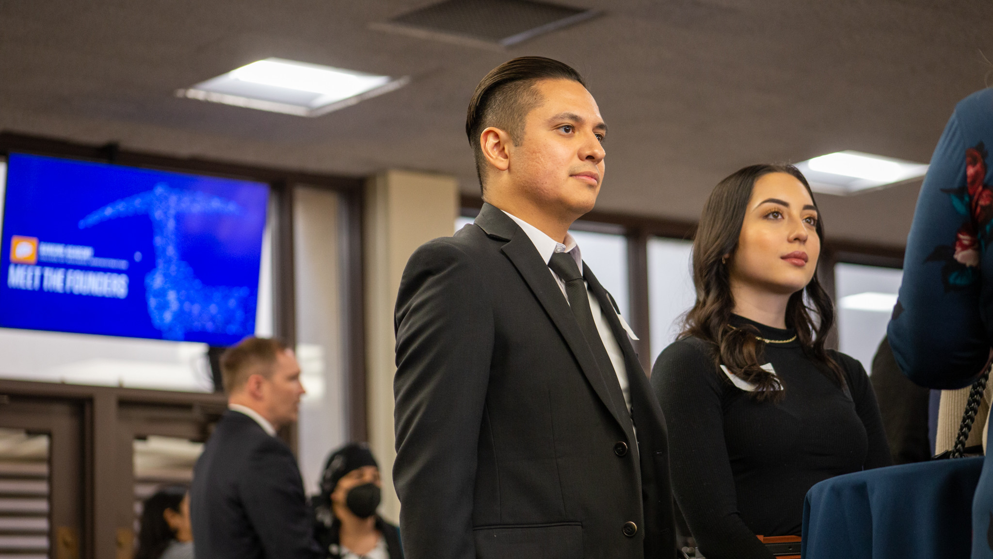 Man and woman listening intently to speaker out of frame