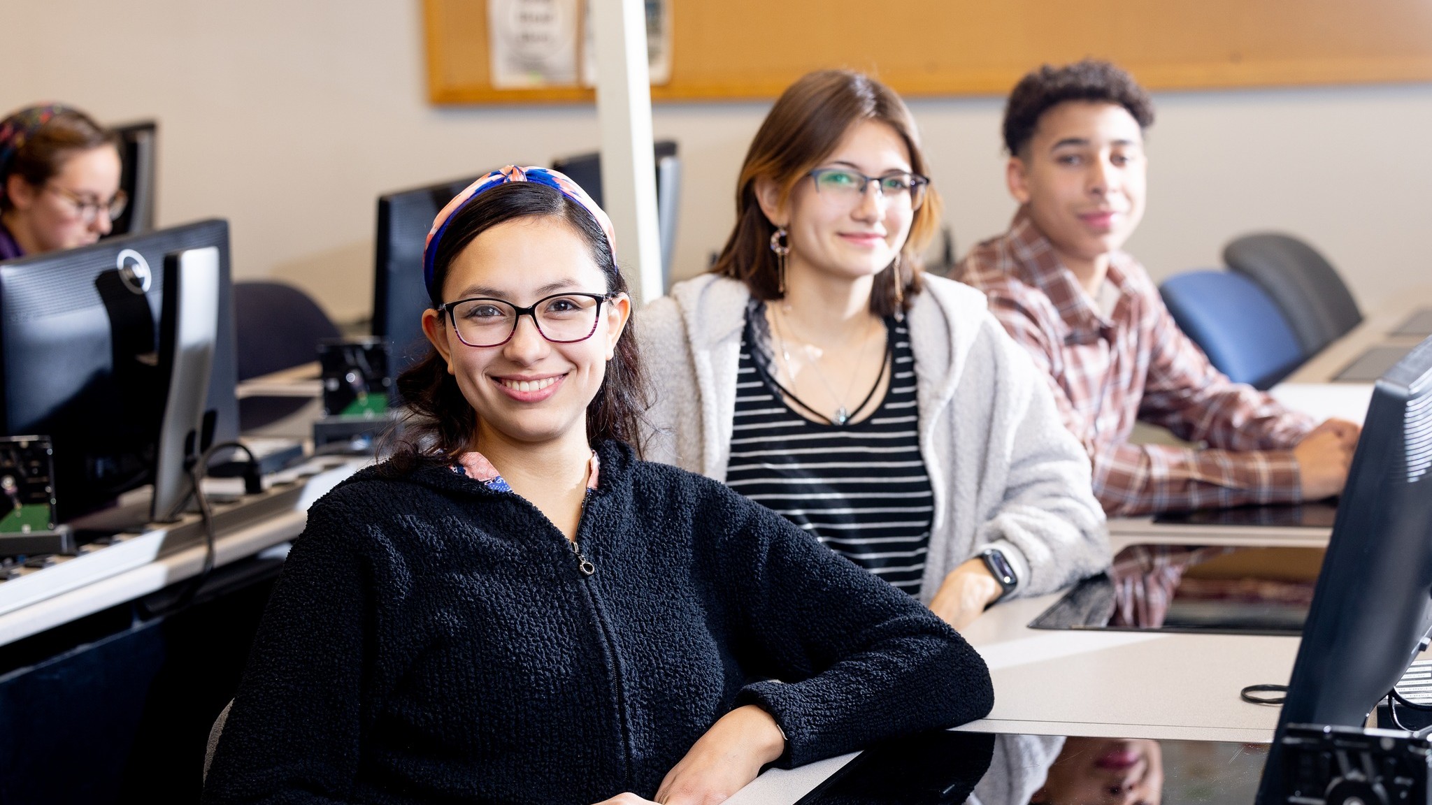 Students posing at computers for Computer Systems and Network Technology program at Mat-Su College