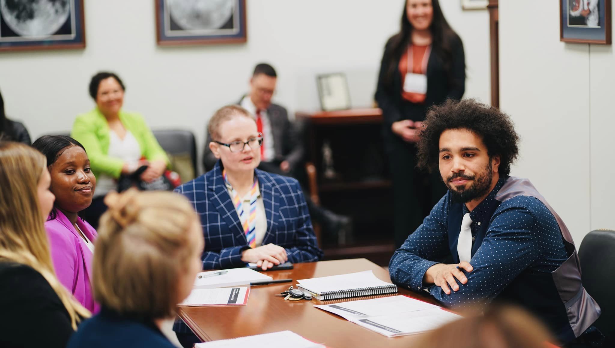 Group of individuals sitting around a table having a conversation