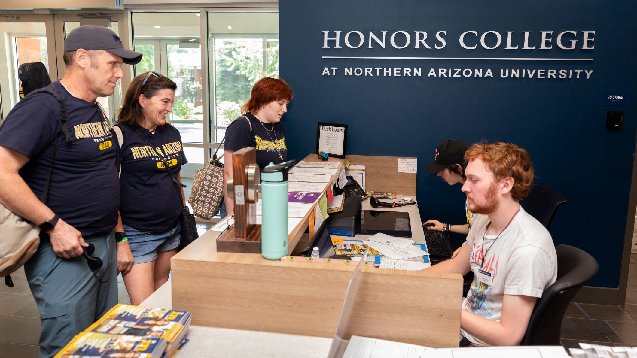 Parents standing at the Honors College front desk during campus move in.