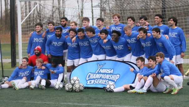 Group of soccer players posing for a team photo on the soccer field