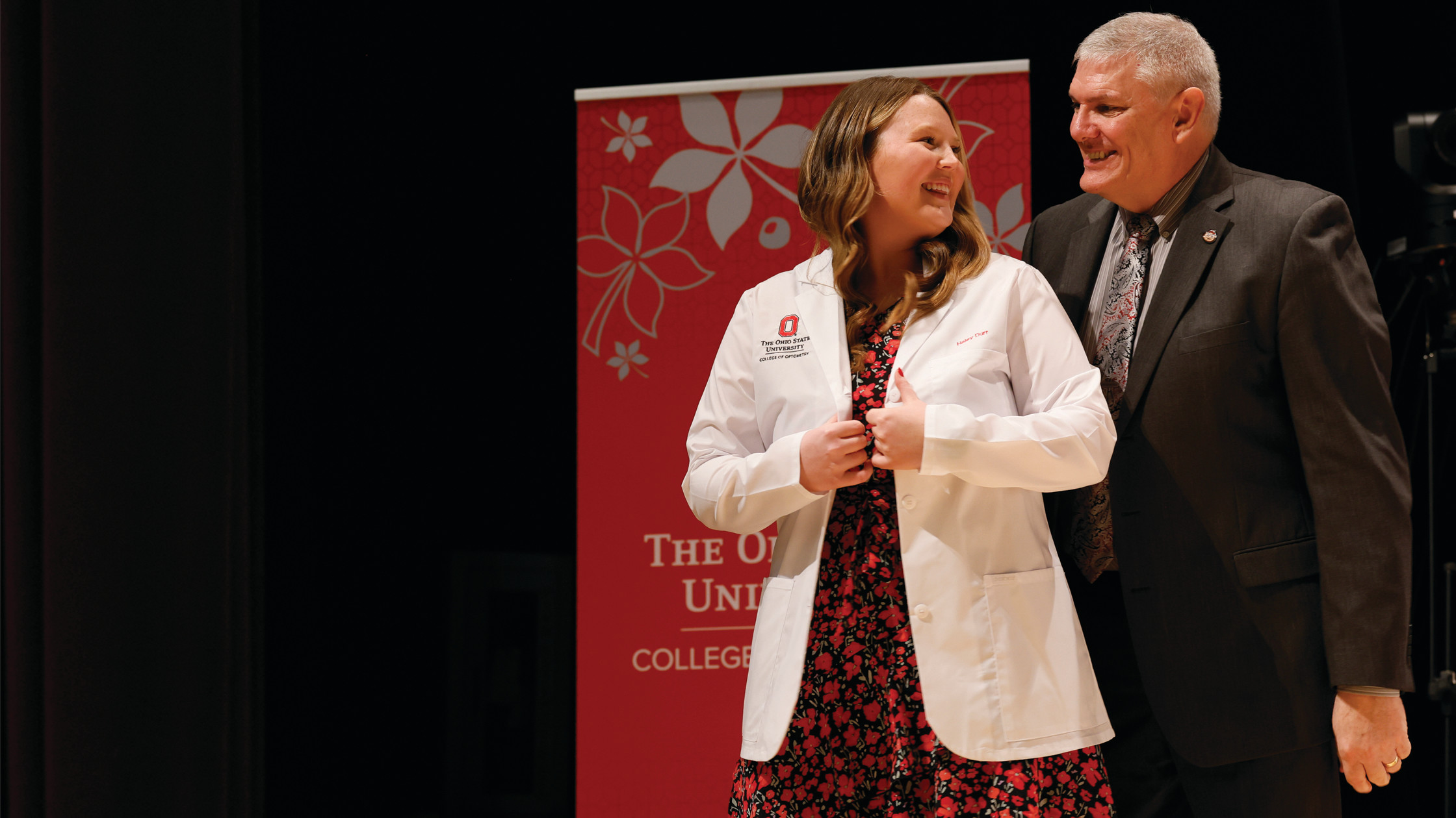 Female student posing in white coat with coater