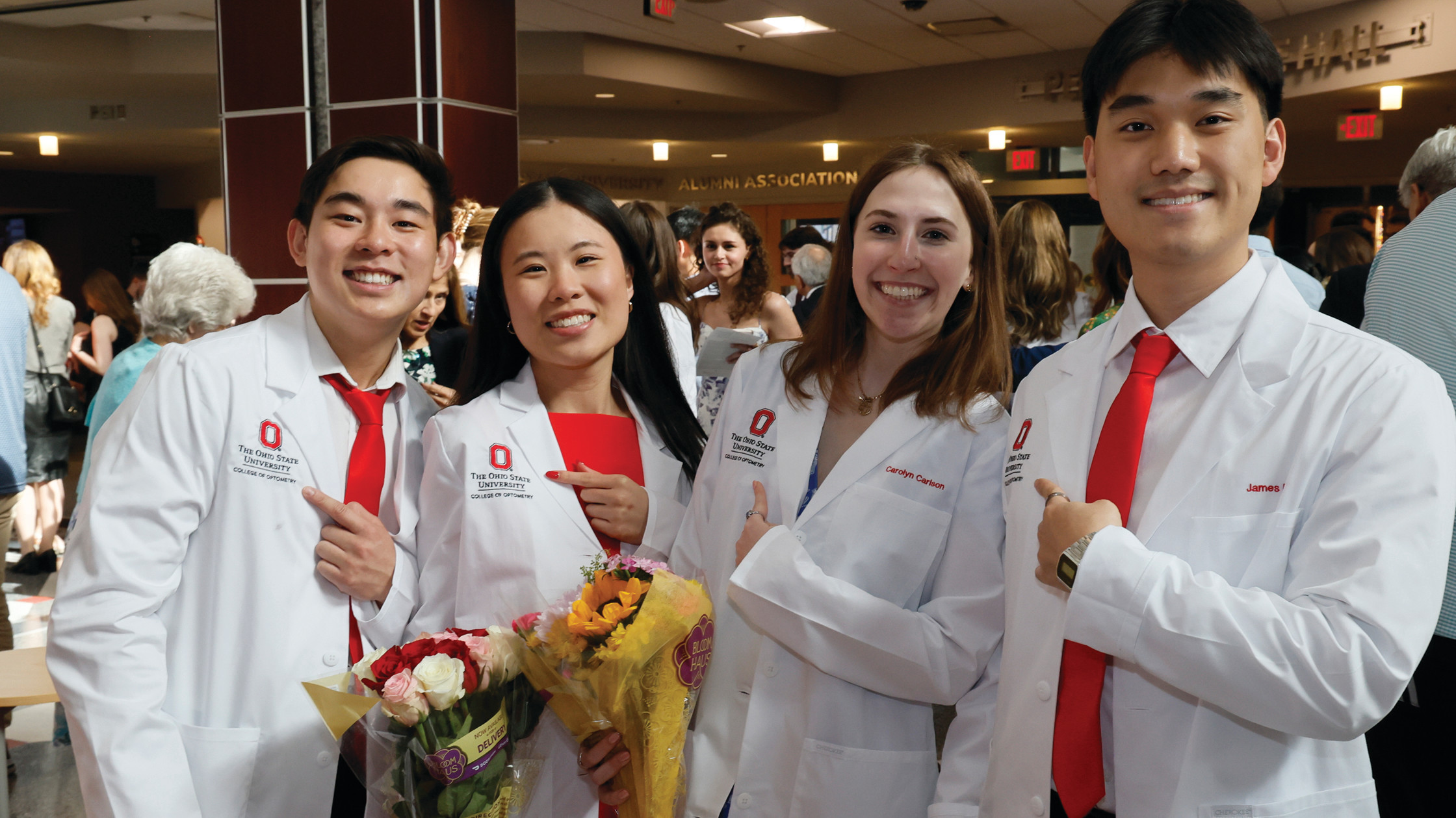Four students posing in white coats