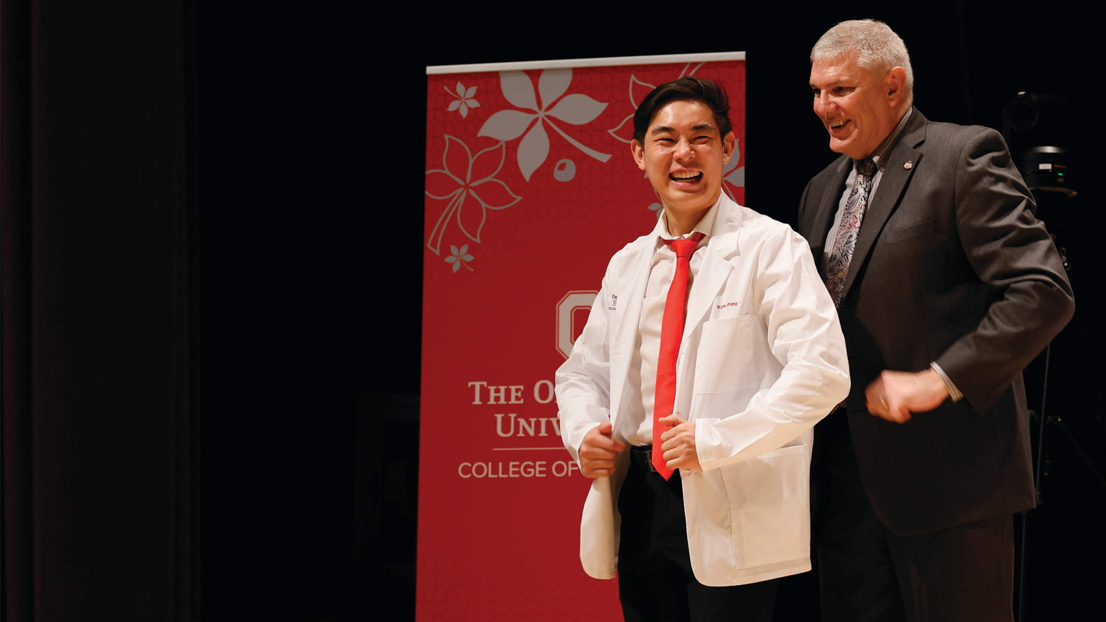 Male student posing in white coat with coater