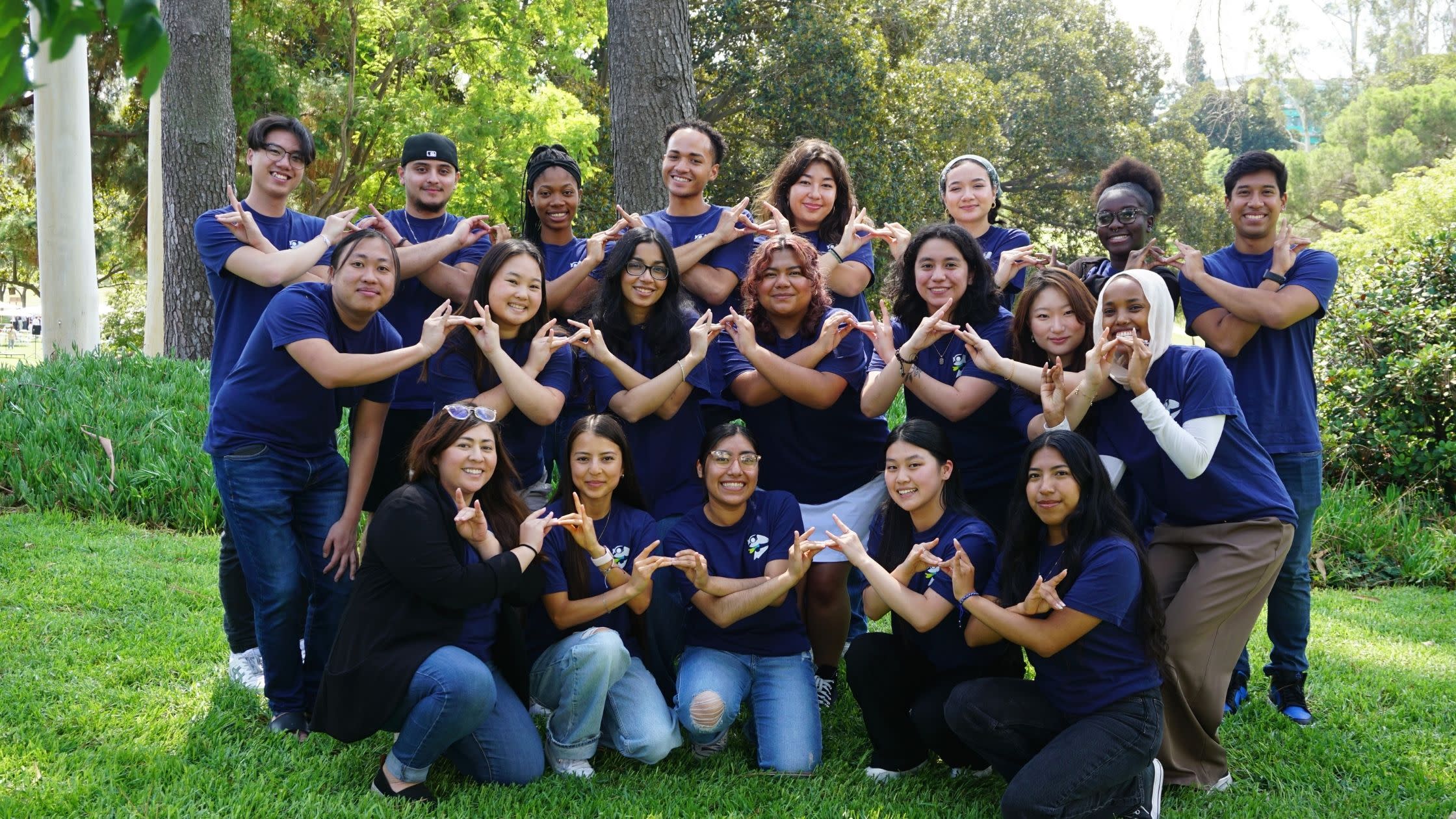 Group of students posing together in matching SOAR t-shirts and holding up the Zot sign
