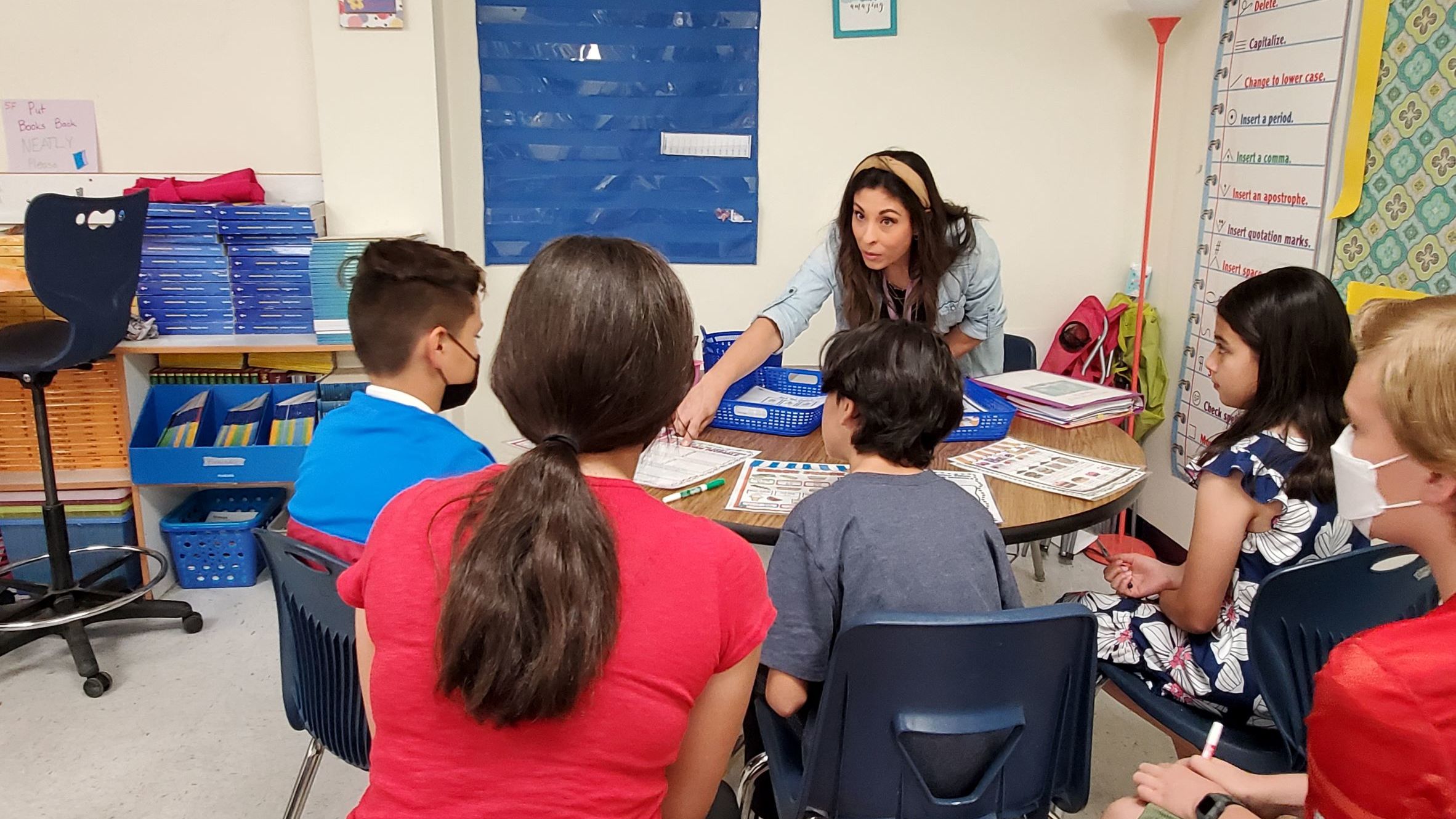 Middle school students with student teach working on homework in a classroom