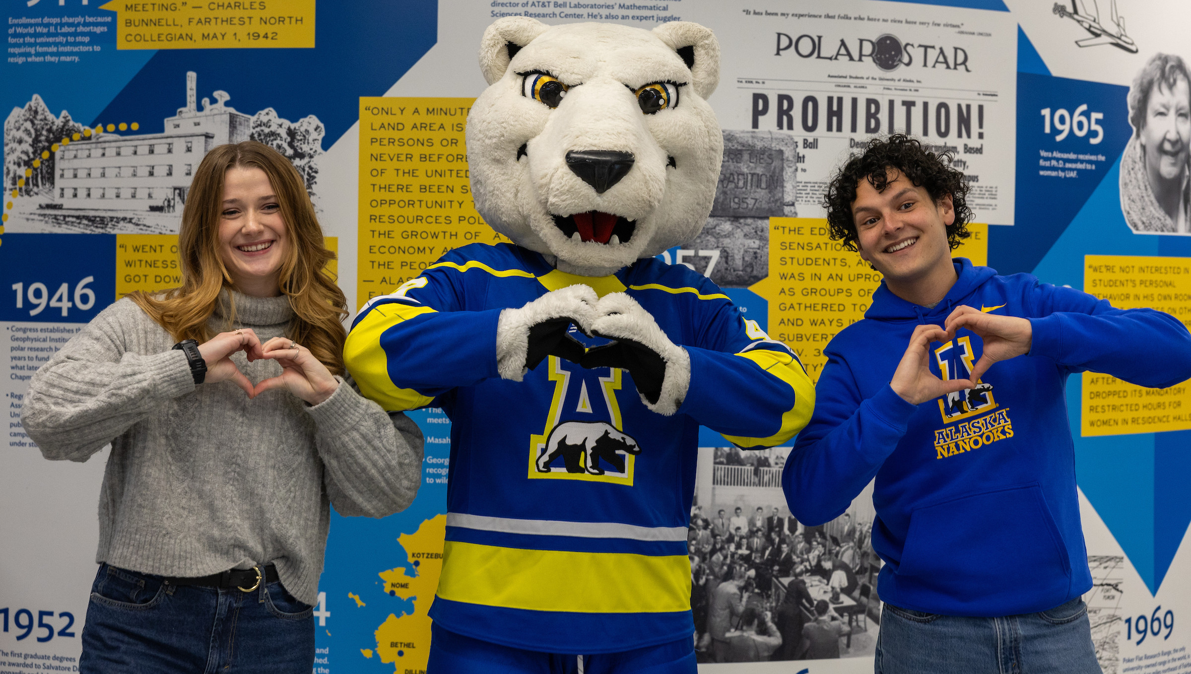 Students and Nook show heart hands in celebration of Giving Tuesday at UAF.