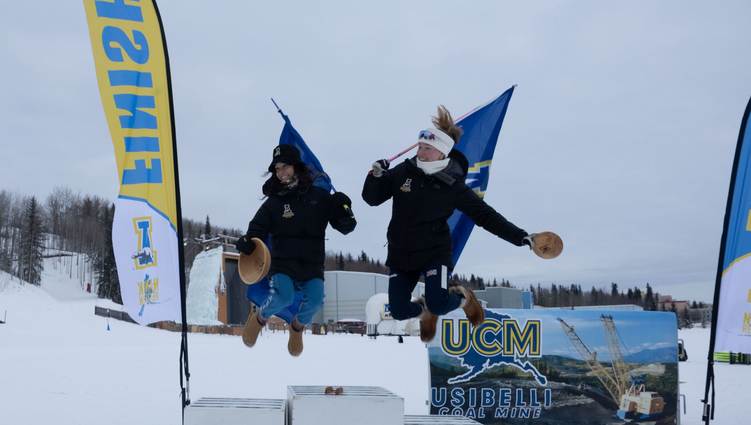Nanook skiers jumping off the podium to celebrate their awards from the 2025 UAF Invite.