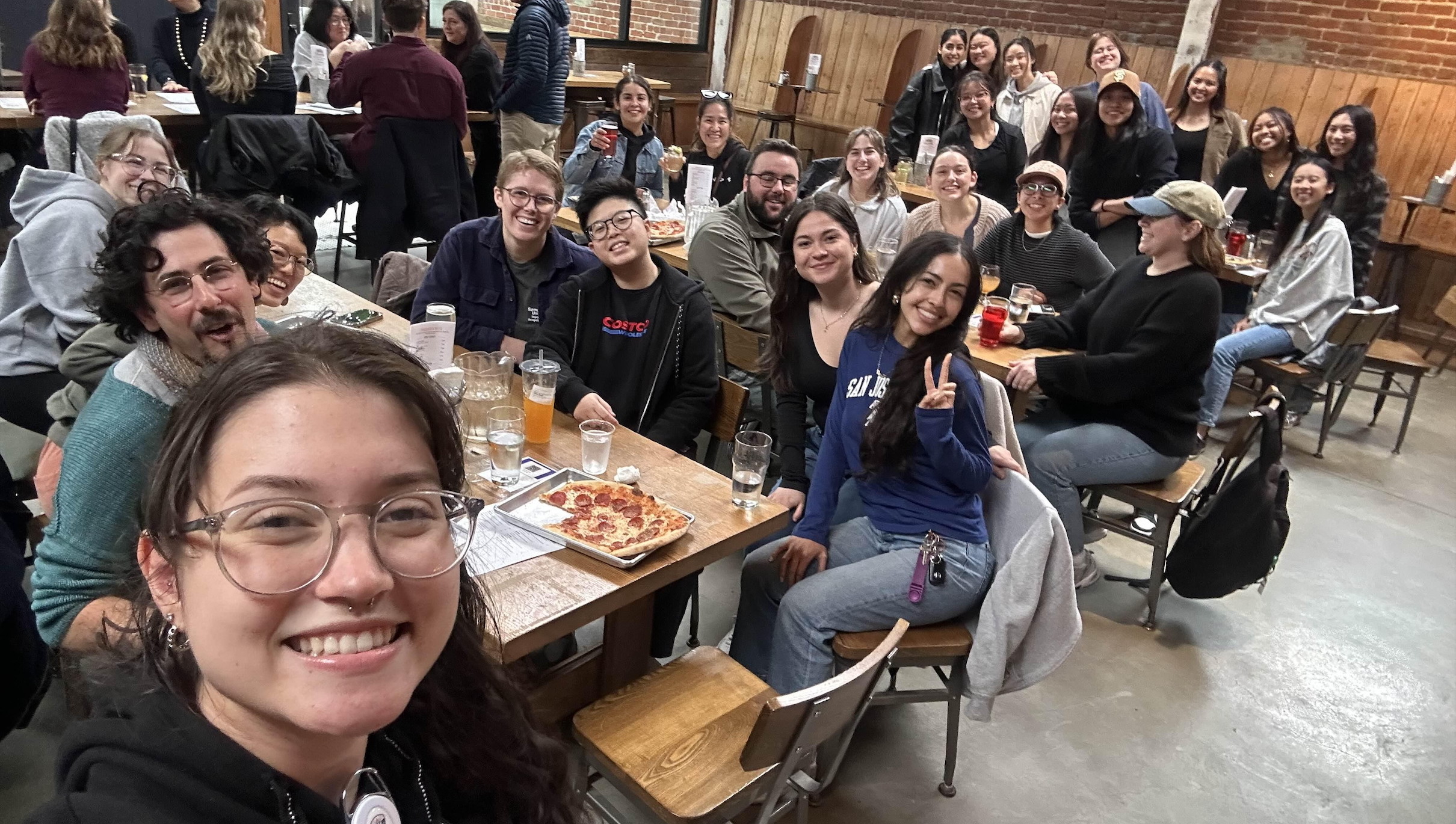 Students taking a group selfie at a restaurant.