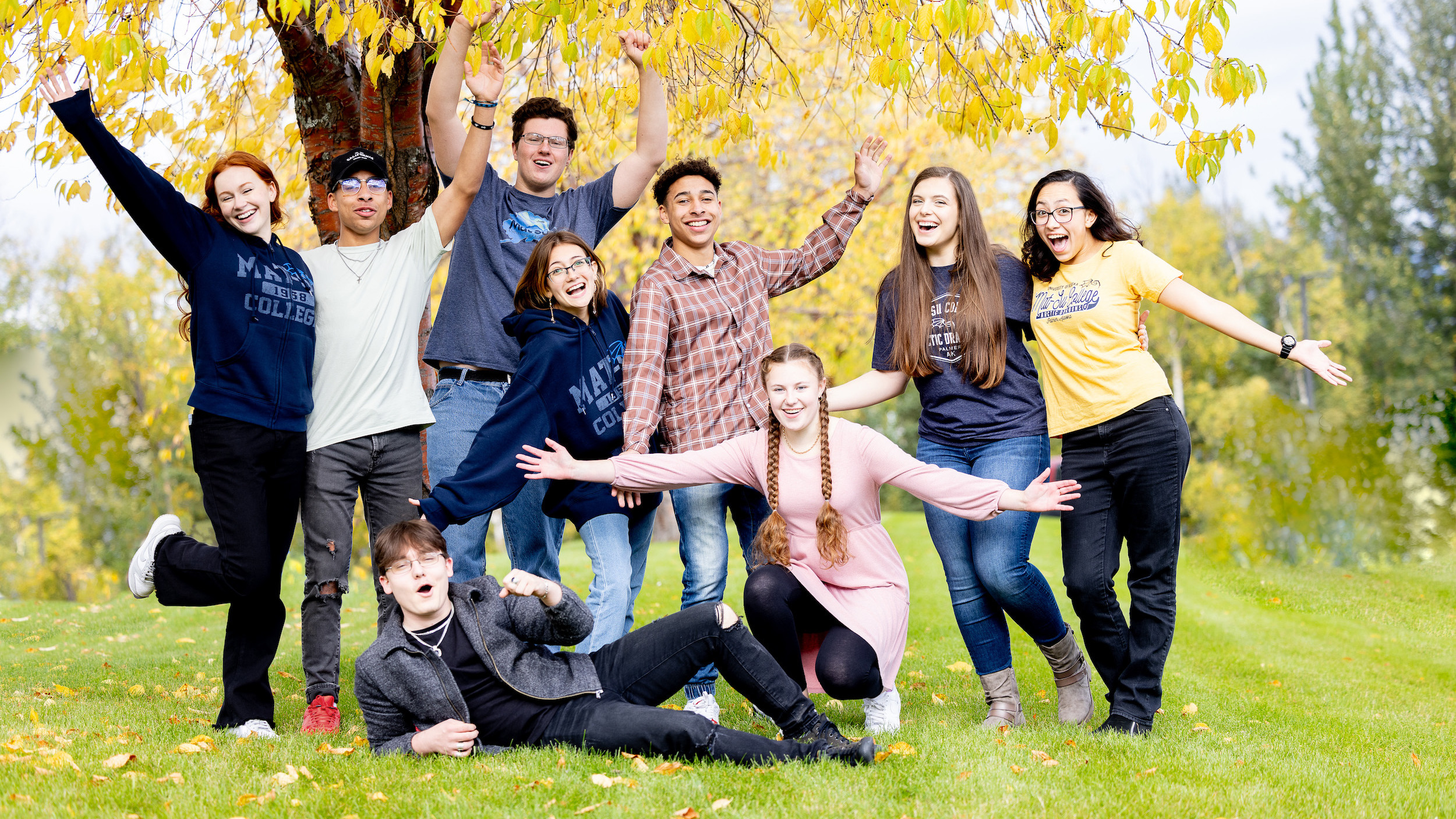 Nine happy and excited Mat-Su Students stand outside on a fall day