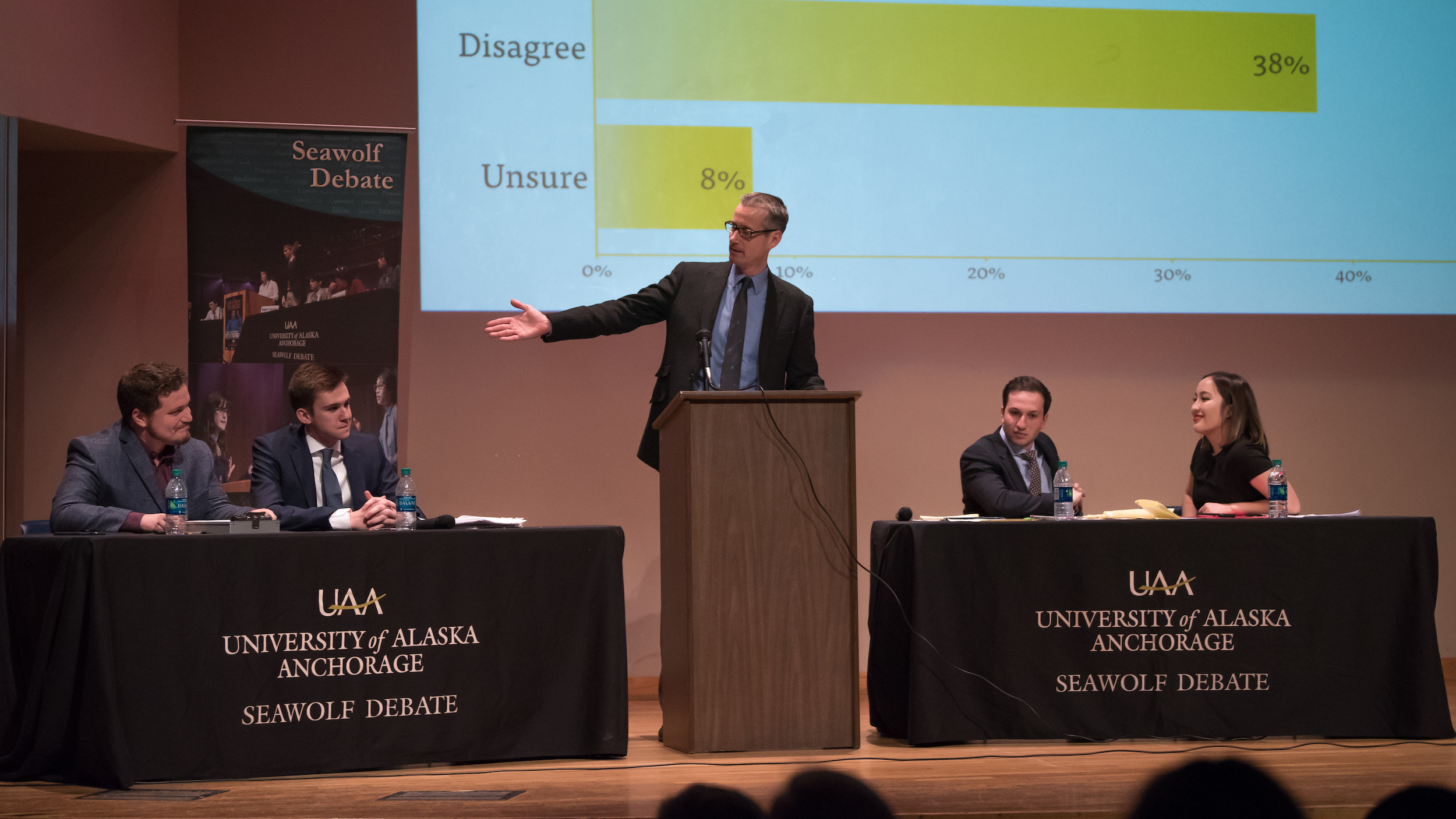 Seawolf Debate team vs. Standford, with moderator in the middle