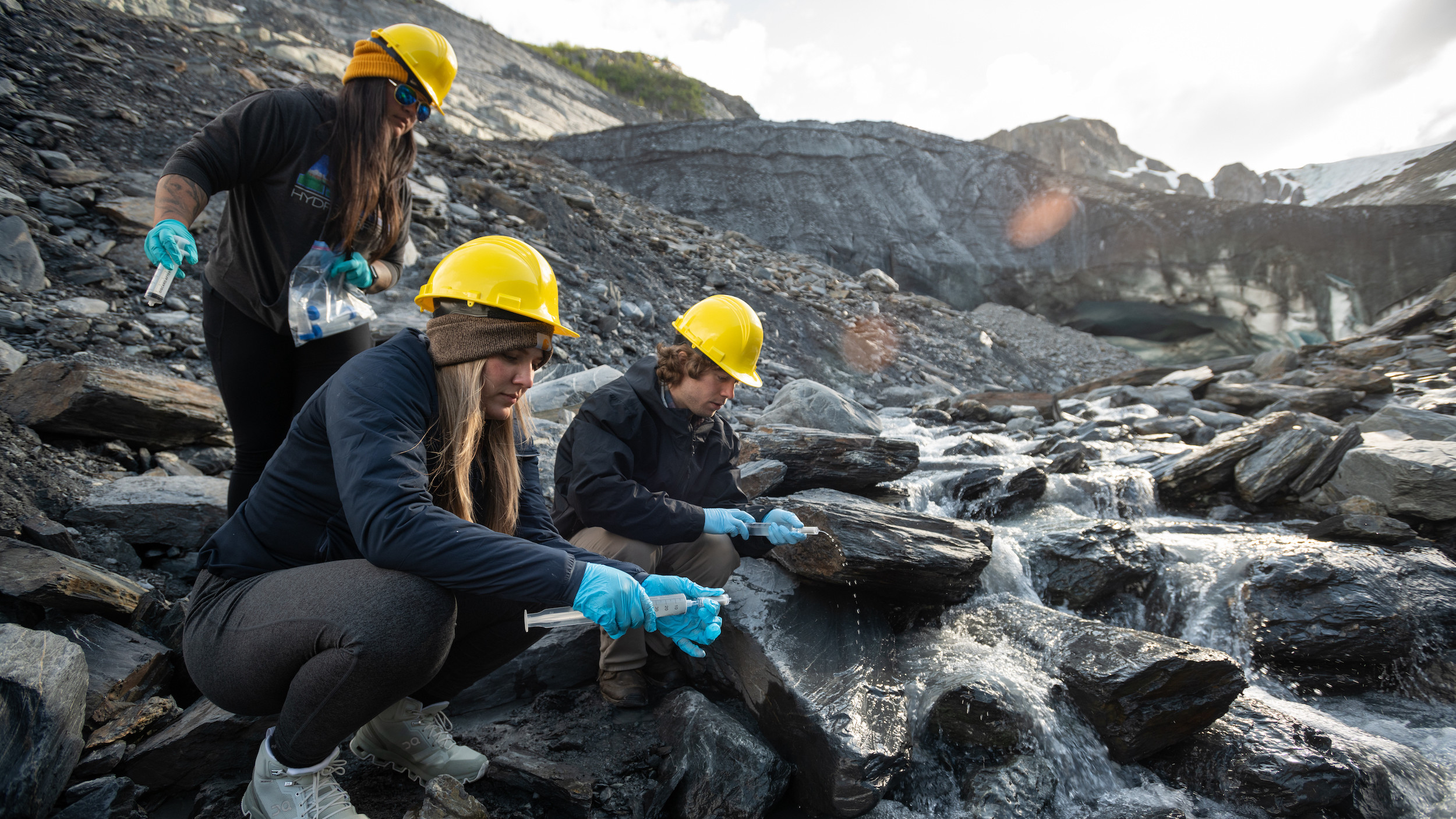 BRIGGS LAB GLACIER MICROBE TRIP, 3 students testing water samples