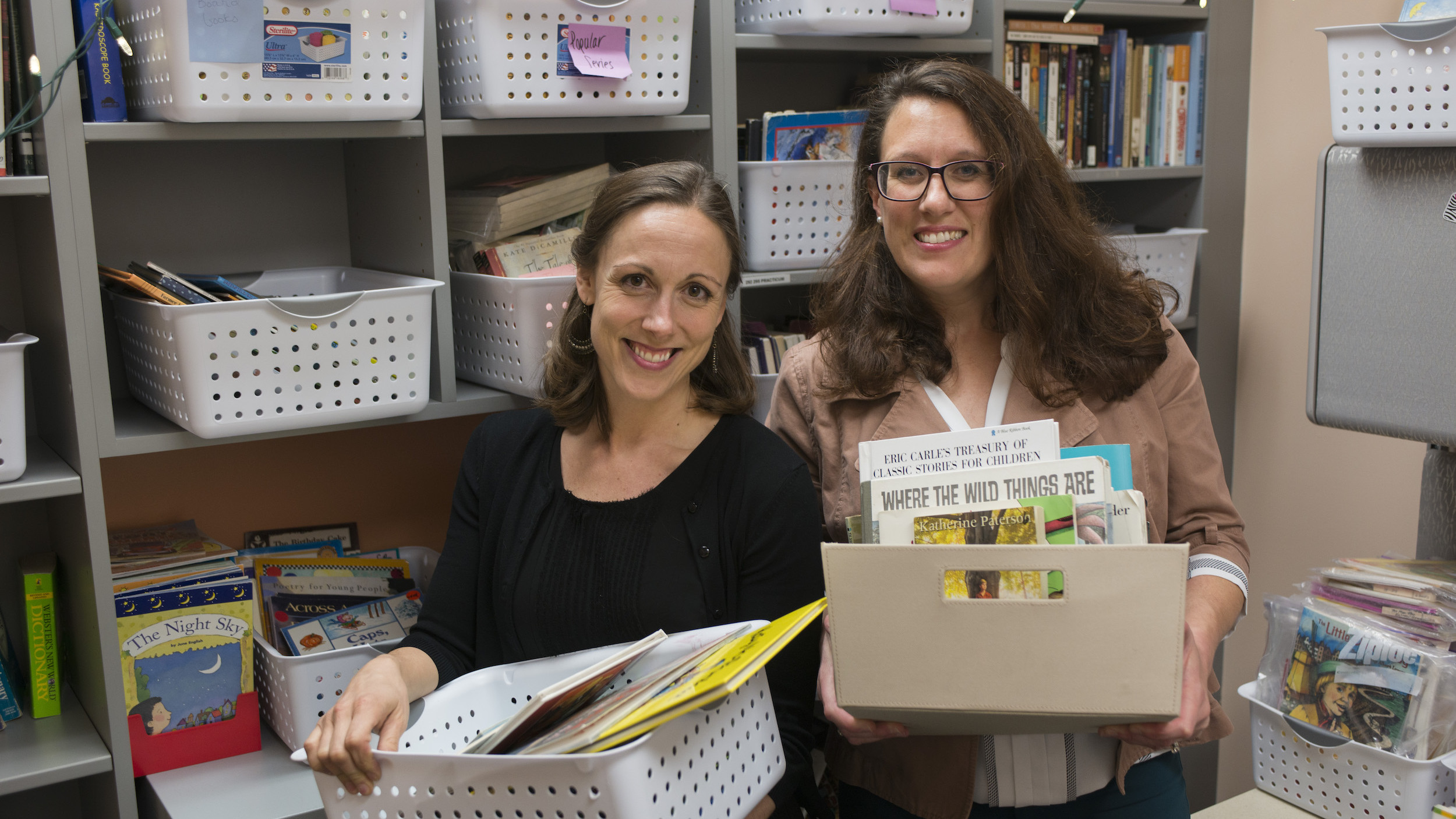 Early Childhood Education Professor and project partner organizing books for UAA Student Teachers