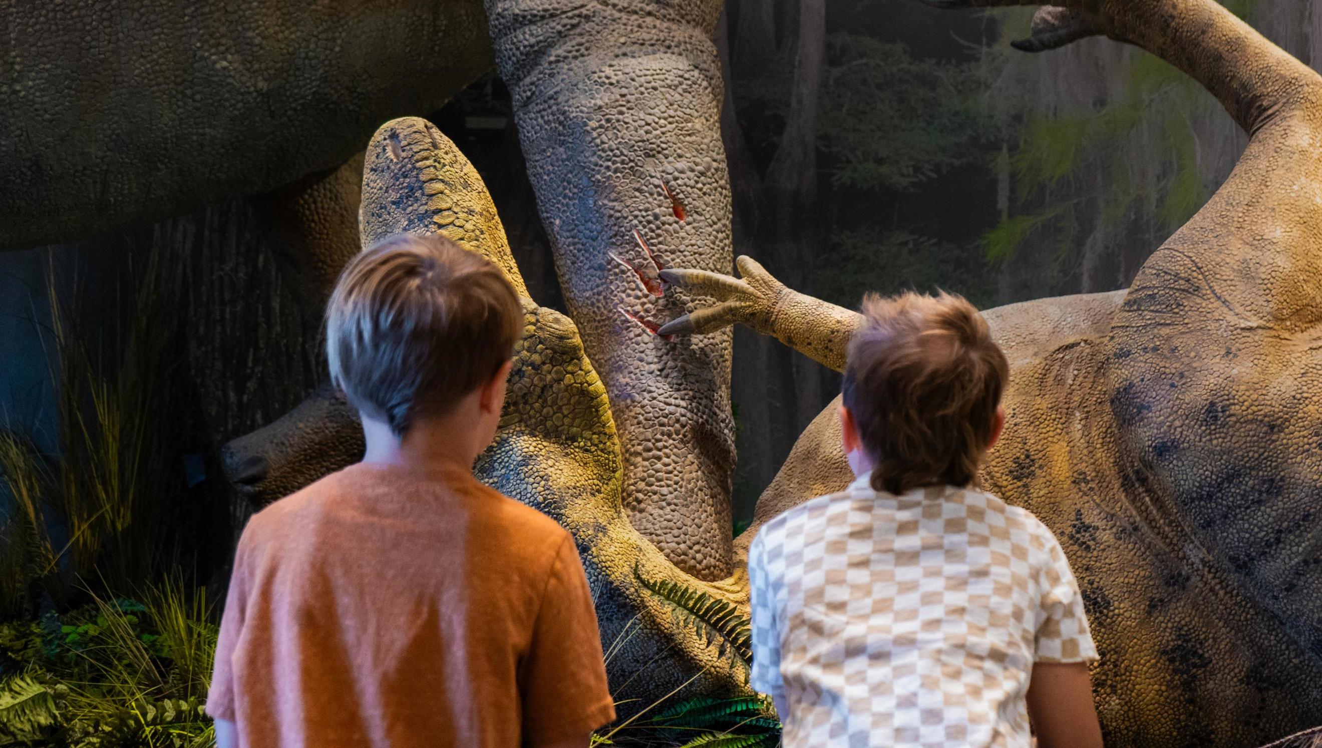 Two children looking at a dinosaur