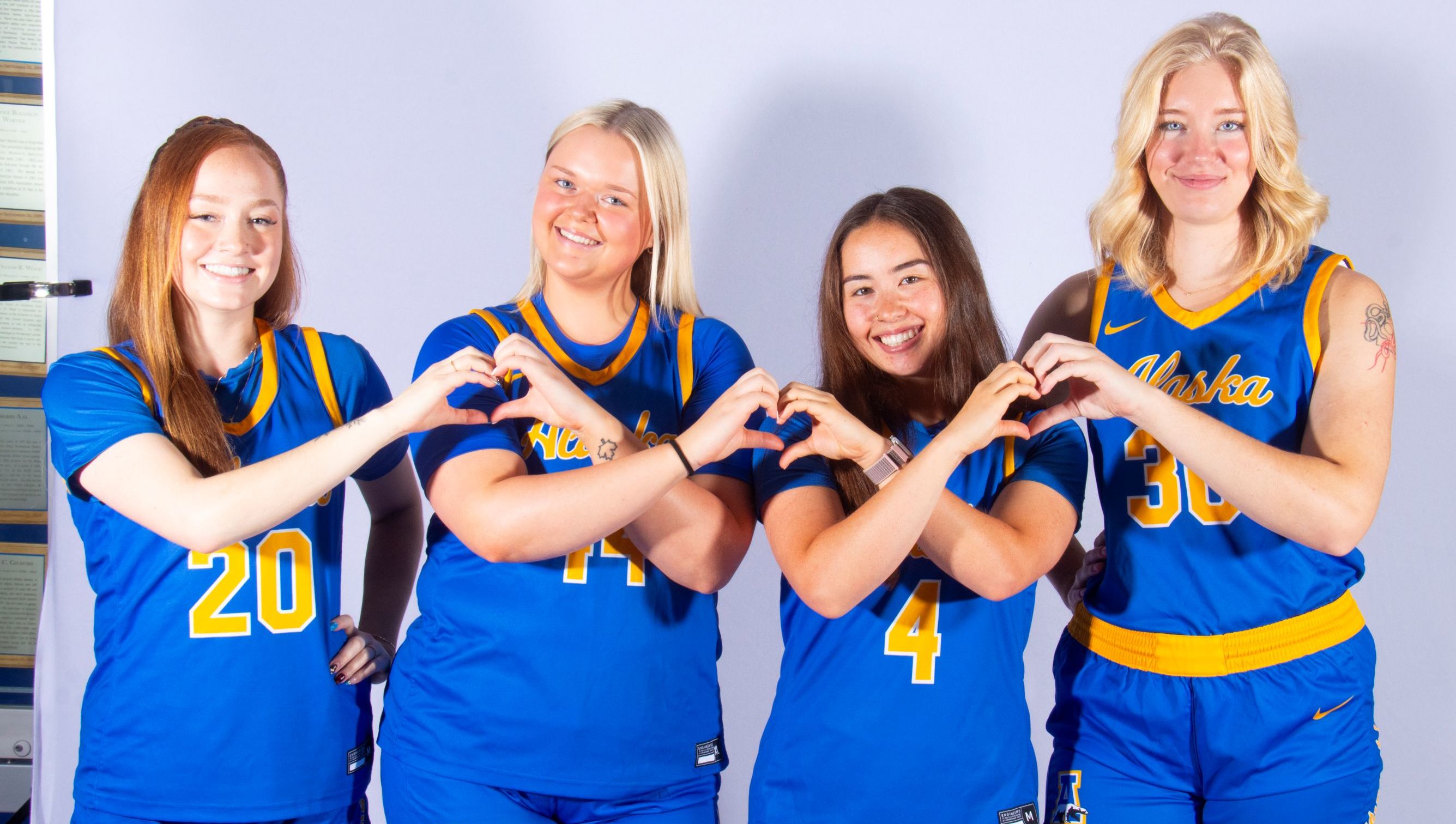 2025-26 alaska nanooks promo photo with heart hands.