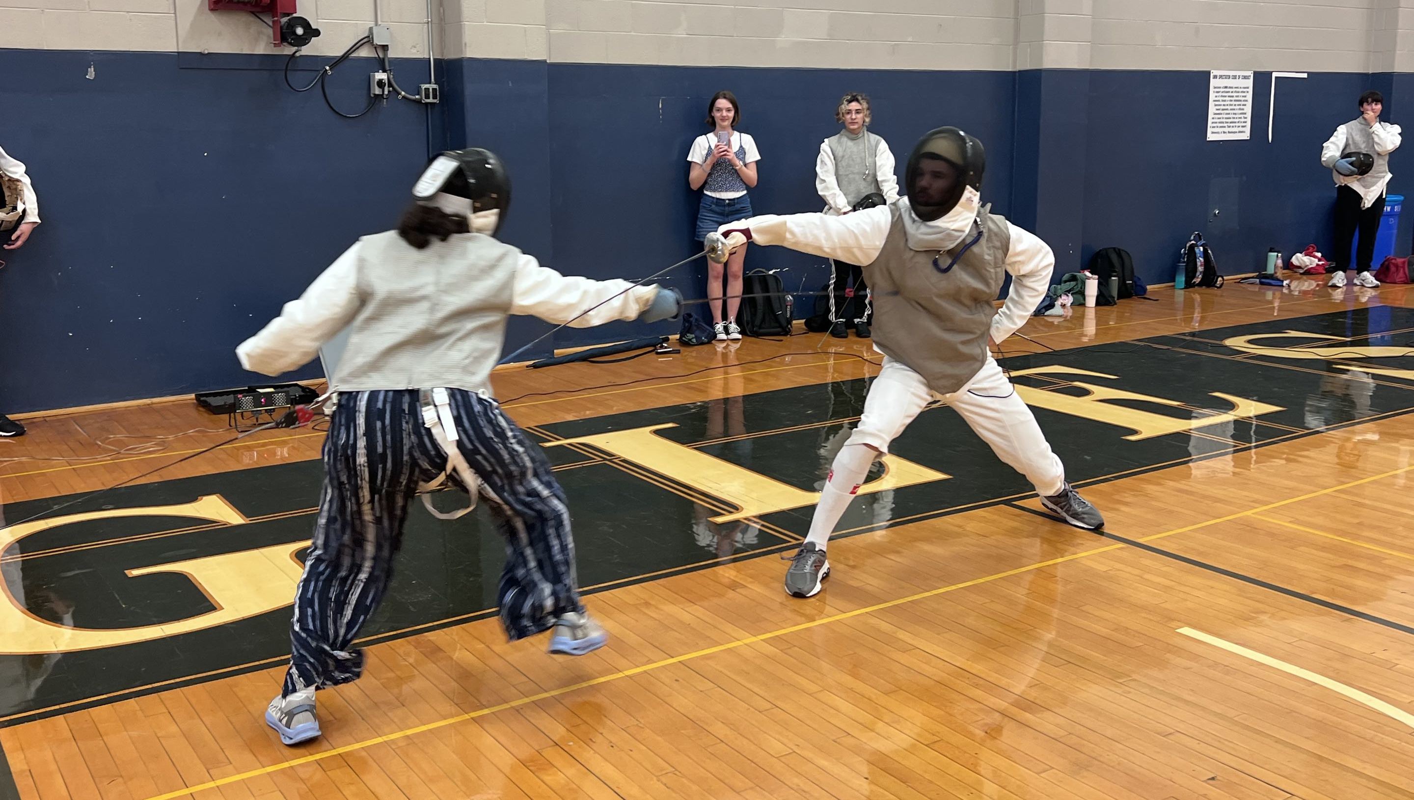 Two fencers in a match against each other