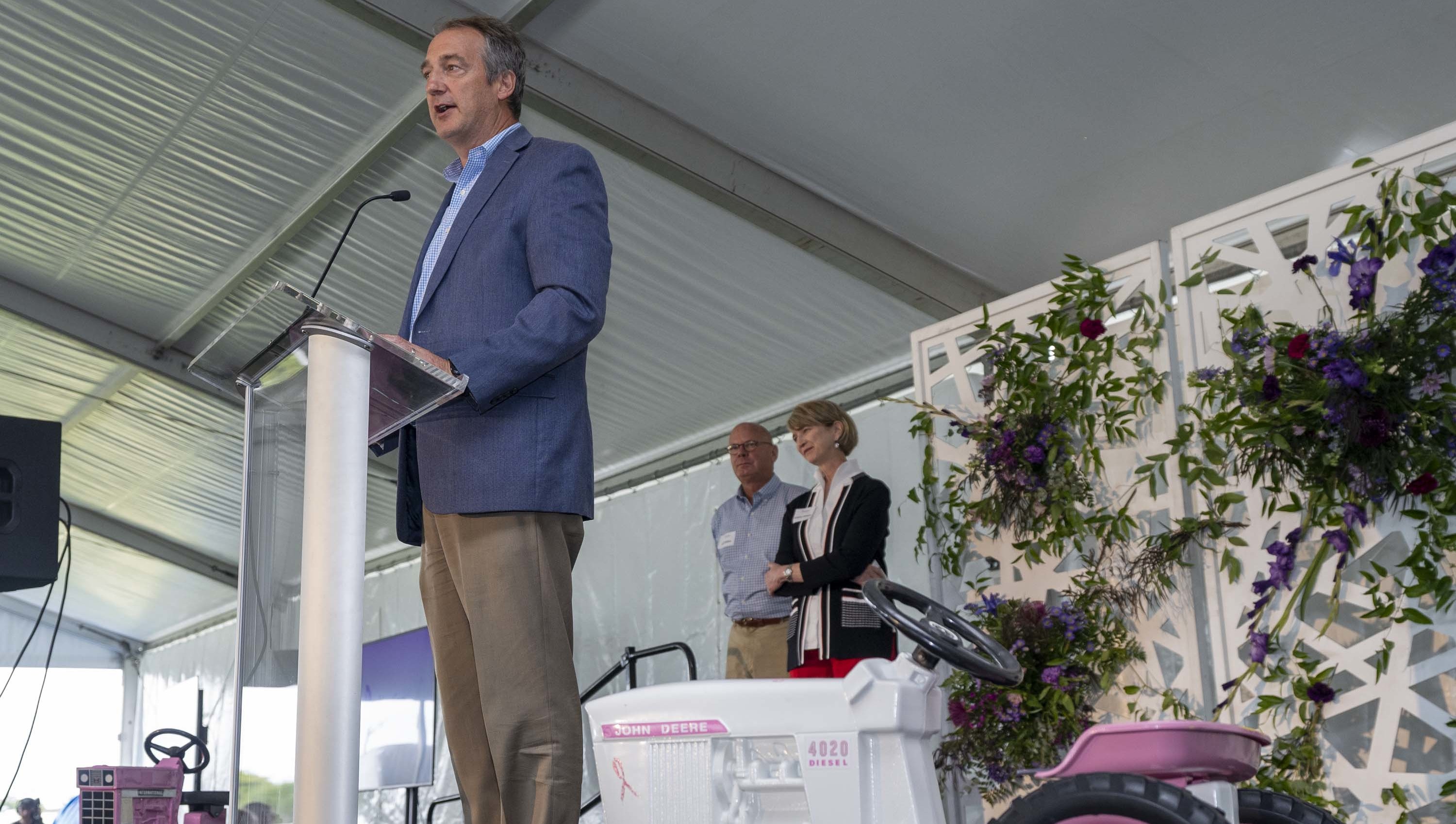 Individual standing at a podium speaking to a crowd