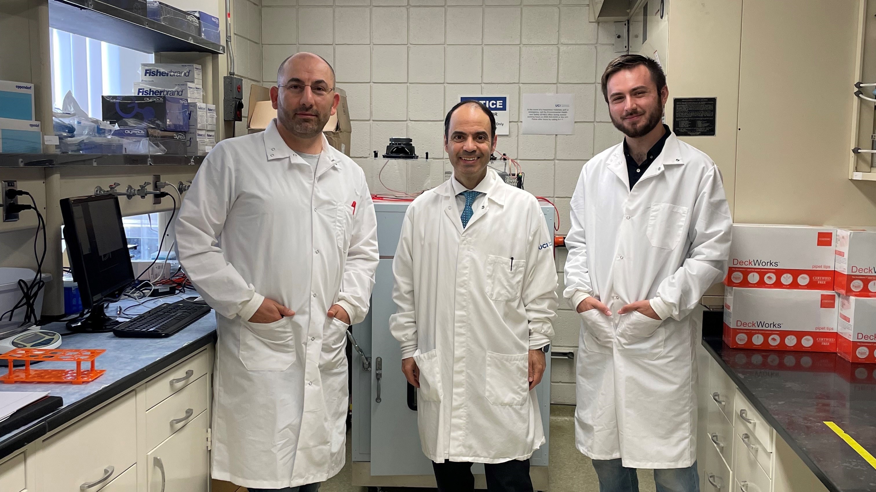 Dr. Hamid Djalilian stands with two other researchers in a laboratory
